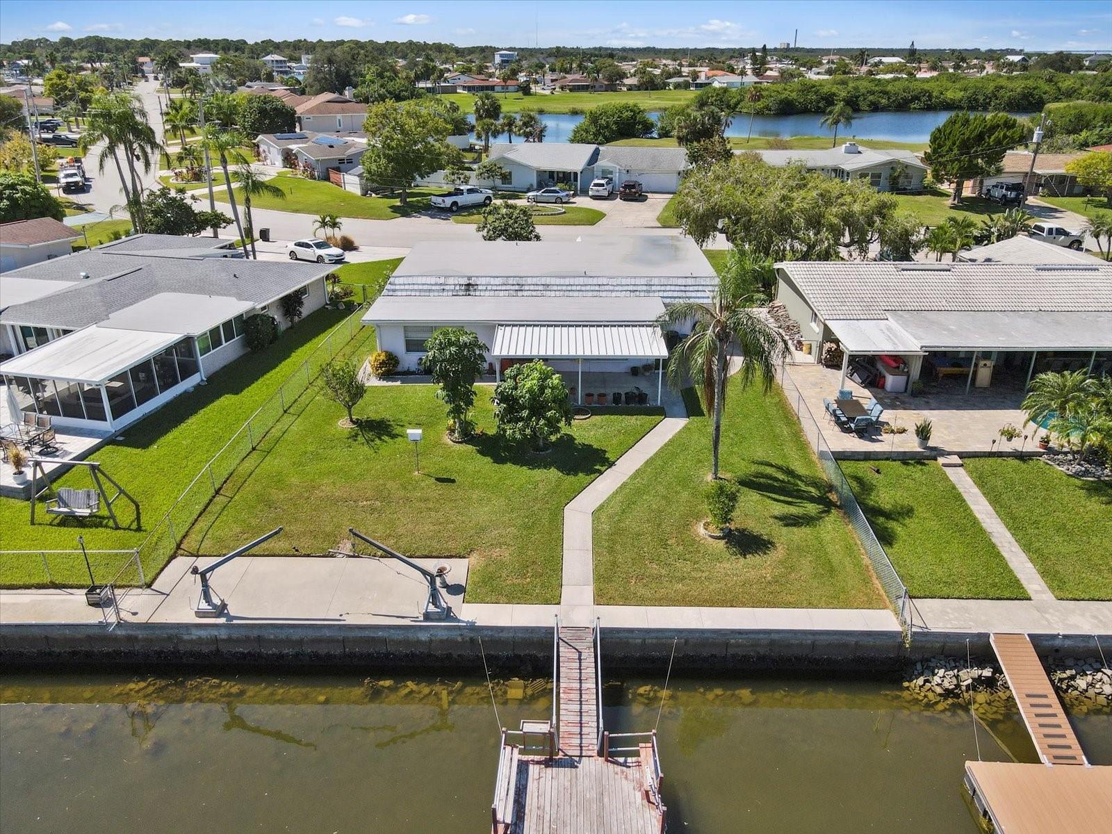 Dreaming of affordable waterfront living? Look no further than this hidden gem in the Gulf Harbors community at 4211 Headsail Dr. This 2-bedroom, 2-bathroom home has undergone a stunning transformation, boasting a BRAND NEW Mansur roof, FRESH interior and exterior paint, and NEW bedroom floors.

As you step inside, you'll be greeted by an open floor plan and all-tile living area. The standout feature is the permitted addition at the back of the home. Which has electric and water accessible. This addition would just need an air vent and to be finished out for INSTANT square footage. Another noteworthy attribute is the flat roof, was thoughtfully replaced in 2022,.

Discover the charm of cedar closets in both generously sized bedrooms, providing comfort and ample space to unwind. The Florida room offer breathtaking waterfront views, creating a serene atmosphere for your morning coffee or hosting delightful gatherings. The property also includes hand crank davits and a floating dock, therefore accessing the water for boating adventures has never been easier.

Situated on a large lot adorned with mango, papaya, lemon, and fig trees, this home is a paradise for garden enthusiasts. The outdoor possibilities are endless, with nearly a quarter of an acre lot and 60 foot of waterfront property you have lots of room for a pool or whatever your heart desires.

HOA to the Gulf Harbors Civic center is OPTIONAL  and includes LOTS of perks including a neighborhood newsletter and a ton of fun planned events all year long to enjoy for $125 a year! The neighborhood also features a Private gated residents ONLY Beach Club for $180 a year which includes a 1/4 mile of white sandy beaches, chairs, cabanas, grills, and beach bathrooms! Your choice to join!

Conveniently located off US 19, this home offers easy access to downtown New Port Richey, ensuring proximity to shopping, dining, and entertainment. Gulf Harbors is also golf cart friendly with fun parades to join in on all year!

Don't miss the chance to call 4211 Headsail Dr your own waterfront haven. Schedule a viewing today and unlock the endless possibilities this home has to offer!