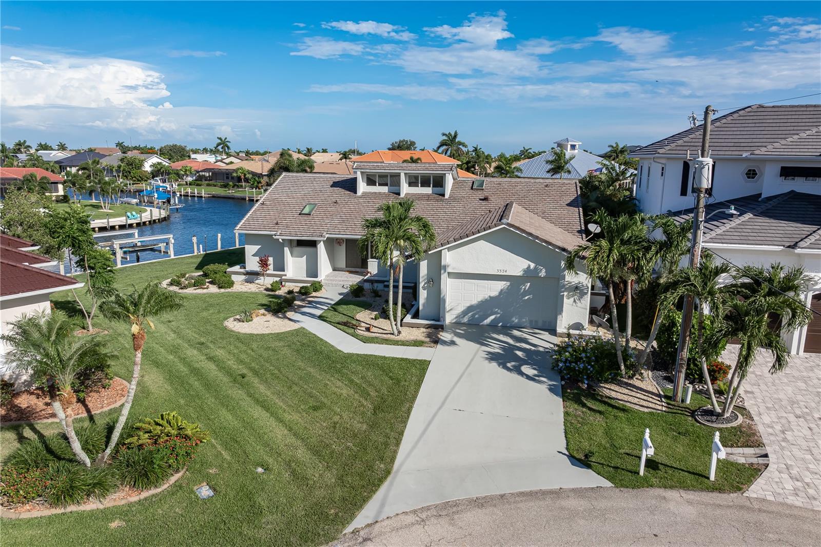 Under contract-accepting backup offers. TIP LOT IN PGI W/INTERSECTING CANAL VIEW, TWO DOCKS & QUICK SAILBOAT ACCESS TO CHARLOTTE HARBOR - This 3 bed/3 bath home in Punta Gorda Isles sits on a tip lot with 141 ft of seawall and a SOUTHERN REAR EXPOSURE. This over 2,200 sq ft home is move-in ready today or it offers a solid foundation for anyone who wants to personalize the finishes and make it entirely their own. A standout feature of this impressive tip lot property is the location of the two docks positioned off to each side of the tip lot. This allows the view to take center stage from almost every room in the home. Inside, the home features a great room layout with formal dining area plus large chef's kitchen and adjacent breakfast area. The kitchen offers ample wood cabinetry, dark granite counters, stainless steel appliances, a large island. The adjacent breakfast area has a built-in desk and a relaxing canal view. Architectural details include soaring cathedral ceilings, a corner fireplace, tile flooring throughout the main living areas and multiple skylights. A wall of sliding glass doors along the back of the home opens to the lanai extending the living space outside so you can enjoy true Florida-style, indoor/outdoor living. The split-bedroom floor plan provides privacy for owners and guests alike. The master suite features two, large walk-in closets, private access to the lanai with pool and canal views plus a spacious bath with dual vanities and generous storage. Both guest bedrooms enjoy convenient access to full baths, with three full baths total. One of the guest baths doubles as a pool bath with access to the lanai. A large laundry room with full-sized washer and dryer boasts additional storage cabinets, a utility sink and a broom closet. Outside, the large, screened lanai surrounds an in-ground heated pool with separate spa. There is a covered seating area and summer kitchen as well. It's the ideal setup for afternoons that stretch into evenings. The wide water views grab your attention from nearly every angle, creating the perfect backdrop for entertaining or relaxing poolside. Southern rear exposure ensures the lanai and pool area will be filled with sunshine throughout the day. Two concrete docks are located steps from the back door. The main dock measures 70x7 and features a 30,000 lb boat lift plus water & electric hook-ups. The second dock measures 30x7 and is located on the opposite end of the tip lot. The City of Punta Gorda maintains the seawalls and canals which is a significant benefit that sets PGI apart from most waterfront communities in SW Florida. Reach open water from your private dock in 10-15 minutes. Additional updates and features include a new roof (2023), hurricane protection, attached two-car garage, and well-maintained tropical landscaping. Exceptional water frontage, outstanding boating access, and one of the best views of intersecting canals make this a unique opportunity. Make an appointment today.