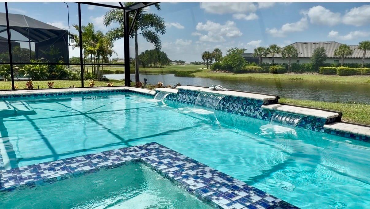 Professional Photography Coming Soon!

Welcome to 15008 Verole Place in Esplanade at Azario, Lakewood Ranch. This beautifully appointed NON-GOLF Lazio offers a rare opportunity to own one of the community's most desirable combinations of floor plan and homesite. Perfectly positioned on a premium waterfront corner homesite, this residence is tucked away on an intimate cul-de-sac with just 16 homes. With only one adjoining residence and an easement providing additional space and privacy, the setting is truly special. The builder is sold out of Lazio non-golf waterfront homes, making this an opportunity no longer available through new construction.

Offering 2,421 square feet, the home features 3 bedrooms, an open den, 3 baths, and tandem 3-car garage. Structural enhancements include the expanded casual dining area, bay windows in both the primary suite and guest bedroom, and the signature tray ceiling package. The expanded primary suite measures approximately 14' x 20' and includes a separate custom built in walk-in closet.

A light-filled, open floor plan showcases 10-foot ceilings, 8-foot doors, crown molding, impact-resistant windows, Storm Smart motorized screens, designer lighting & ceiling fans, automatic shades, blinds, and sealed wood-look tile flooring throughout the main living areas. The kitchen features upgraded painted cabinetry with soft-close doors and full-extension drawers, quartz countertops, GE stainless steel appliances, including the refrigerator, and an oversized island perfect for entertaining.

The extended covered lanai is designed for year-round enjoyment with a custom vented outdoor kitchen, an oversized saltwater pool and spa with paver deck overlooking tranquil water with a glimpse of the golf course beyond. The desirable southwest rear exposure provides all-day sunshine across the pool and spectacular Florida sunsets.

Additional upgrades include a Lutron smart lighting and alarm system, Aqua Pure water softener, whole-house lightning surge protection, and a Westinghouse 14.5 kW remote-start tri-fuel generator with a professionally installed 50-amp inlet.

Esplanade at Azario offers a true resort lifestyle with a spectacular pool, Bahama Bar, Culinary Center, fitness center, spa, tennis, pickleball, bocce, dog park, walking trails, and an active social calendar. Owners also have the opportunity to purchase an Annual Golf Membership (subject to availability), providing championship golf without mandatory deeded golf fees.

With its premium homesite, exceptional finishes, and outstanding location, 15008 Verole Place offers an extraordinary opportunity to enjoy luxury living in one of Lakewood Ranch's premier resort communities.