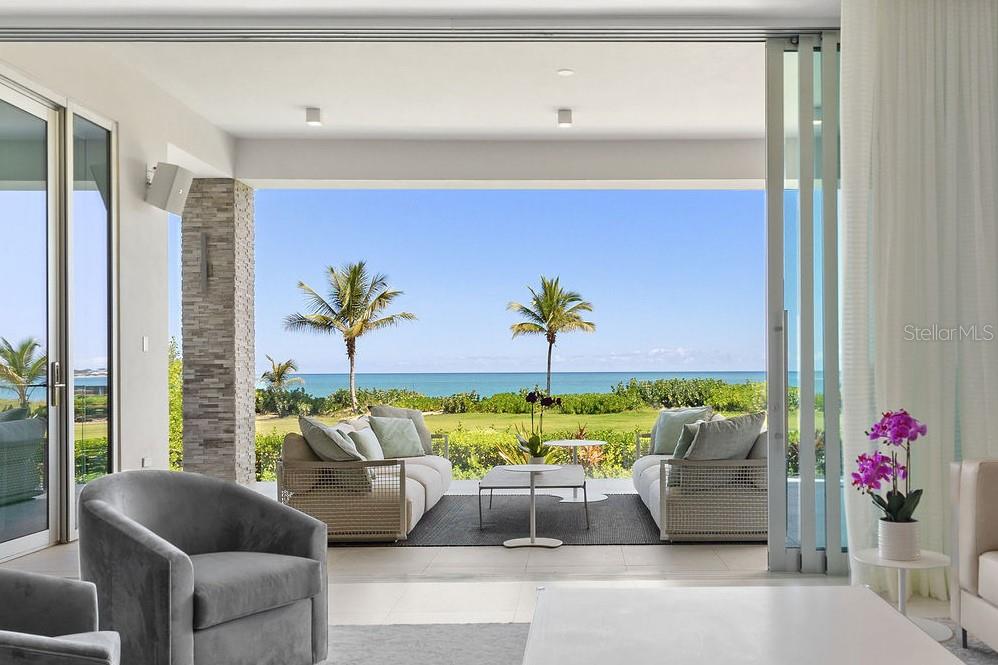 Within Bahia Beach Resort in Río Grande, we proudly present St. Regis-branded Ocean Drive Beachfront Residences—a truly spectacular garden apartment that exemplifies luxury living. This remarkable residence offers an unparalleled lifestyle experience with its beachfront location and awe-inspiring panoramic ocean views that greet you from every room. Imagine waking up to the soothing sound of waves and the mesmerizing sight of the Atlantic Ocean right from the comfort of your own home.
 
This thoughtfully designed garden apartment boasts an expansive terrace complete with an outdoor kitchen and a captivating pool, creating an ideal space for both relaxation and entertainment. Step outside and you're just a leisurely stroll away from the pristine beach, allowing you to indulge in the sand and relax whenever you desire. With three generously-sized bedrooms, each featuring its own lavish bathroom and walk-in closet, as well as a convenient powder room, this residence spans an impressive 5,568 square feet, offering ample space for both privacy and hosting guests.
 
Designed by the renowned SB Architects Miami and in collaboration with the global firm Hirsch, Bender, and Associates, this home is a masterpiece of modern luxury. The kitchen is adorned with Poliform Italian cabinetry and outfitted with Wolf and Sub-Zero high-end appliances, catering to the culinary enthusiast's every need. For convenience, this property includes two parking spaces, one of which comes equipped with an EV charger, as well as a dedicated golf cart parking spot and additional storage.
 
The attention to detail and technology integration is impeccable, featuring floor-to-ceiling impact-proof sliding windows that bring the outdoors in, a cutting-edge SmartHome system, Lutron audio, and Sonos speakers throughout the residence and pool area, ensuring a seamless blend of comfort and convenience.
 
As a resident of the St. Regis Ocean Drive Beachfront Residences, you will have access to a host of exclusive amenities, including the opportunity to explore the outdoor paradise of Bahia Beach Resort with its sprawling lakes and rivers, spanning over 400 acres and housing a Certified Gold Audubon International Signature wildlife sanctuary. Additionally, two bird sanctuaries, an on-site team of marine biologists, diverse dining options, The St. Regis Bar, an ocean-front golf course designed by Robert Trent Jones Jr., and a world-class spa await you.
 
This is not just a residence; it's a lifestyle where you can savor panoramic views of the Atlantic Ocean and Bahia's two miles of crescent beach. As a bonus, the St. Regis offers an optional rental program compliant with Marriott’s requirements, allowing you to seamlessly rent out your unit as part of their inventory when not in use. Furthermore, as a branded St. Regis Residence owner, you gain access to a plethora of a-la-carte services offered by the hotel, including in-residence dining, dry cleaning services, housekeeping, and more. It's the perfect blend of elegance, convenience, and natural beauty, awaiting the discerning buyer ready to embrace the St. Regis lifestyle.