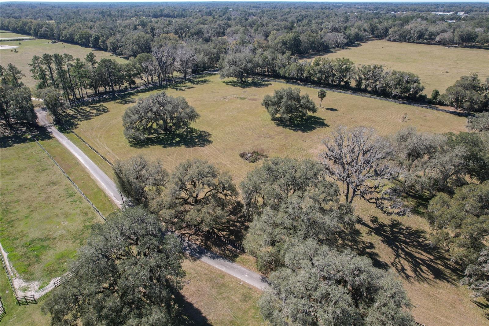 AMAZING LOCATION, with a price improvement on almost 40 acres just a stone's throw from HITS and 15 minutes to WEC .  This is the ultimate working horse farm with a generator that runs both the house and barn so there is never a need to worry about water or light to care for the horses.  Enter the magnificent tree shaded drive with cross county jumps, a pond and turnout for grazing on the left.   A jump arena with all weather footing is on the right.  The dressage arena also has all weather footing and there is a separate well for irrigation for both rings.  The majority of the newer built 21 paddocks have large oak trees providing shade.  One barn has 17 12x12 ft. stalls plus room for more. 2 new Big Ass fans, laundry, bathroom, feed and tack rooms are in the large barn .  The small barn has 4 stalls including a large foaling stall with a tack and feed room. In addition there are 2 mare motels and 1 run in shed with 2 separate large paddocks.  All farm equipment, including newer tractor, drags and zero turn mower will stay.  Lots of open level space for additional paddocks or a grass arena.  Enter the home through beautiful wood double doors from the front porch with an office to the left.  The 5 bedroom house has a chef's kitchen with a walk-in pantry, 2 sinks, gas stove with 2 ovens and griddle plus a breakfast bar and granite counters.  2 primary bedrooms, 1 up and 1 down along with an office to work in right off the front entrance.  No carpet to deal with.  The 2nd story bedrooms have balcony access overlooking the pool. There's a wood burning fireplace in the living room for those chillier days. The laundry/mud room has a separate outside entrance so no need to track through the house. Multiple sliding glass doors from downstairs primary bedroom, kitchen and living room give access to the generously sized screened-in pool area with room to entertain or just relax.  Large on-demand water heaters add to the livability of this home.  A shed with overhangs on both sides allow for equipment or vehicle storage under cover. There are 2 RV hook-ups close to the barn.  This property has incredible trees, great grass and a fabulous location.  It has been set up for ease of use and is ready to move in and make your own.