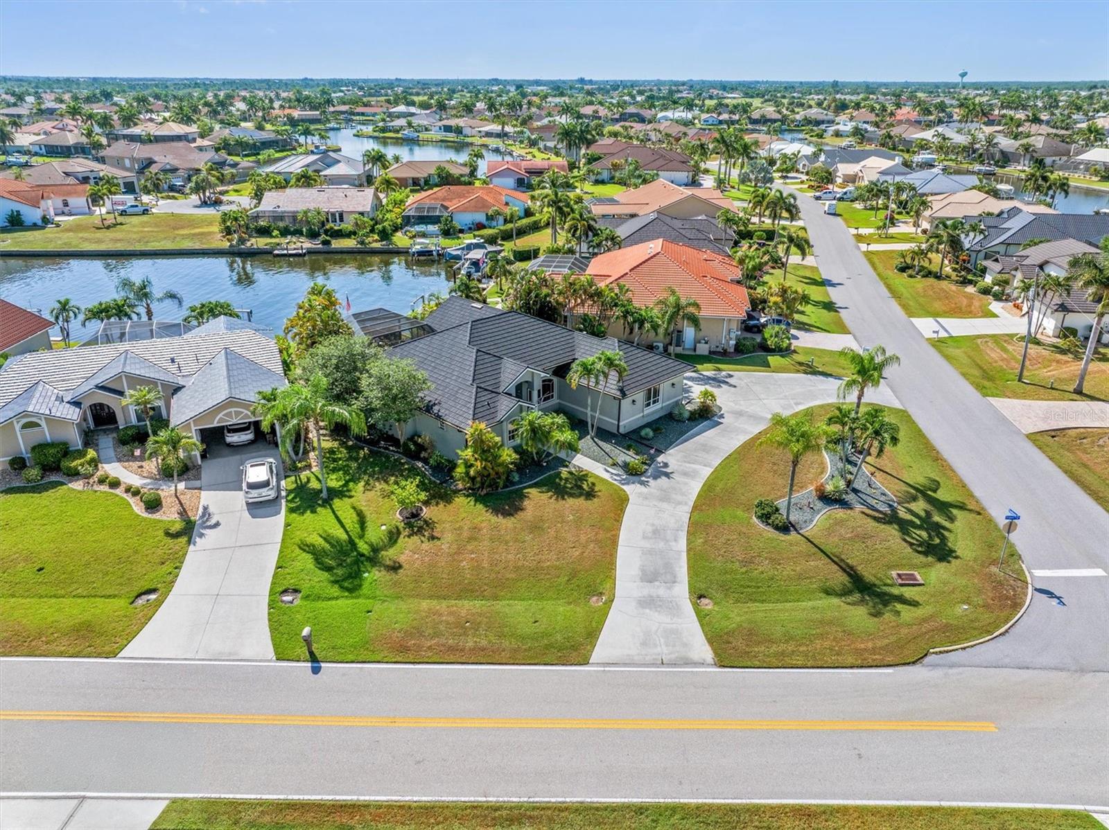 Experience the very best of Southwest Florida WATERFRONT living in this exceptional custom home on SAILBOAT WATER in BURNT STORE ISLES. Built by renowned local builder Tim Towles, this beautifully crafted residence blends timeless design, quality construction, and thoughtful upgrades with the boating lifestyle you've been dreaming of.  From the moment you arrive, the CIRCULAR DRIVEWAY, side-entry garage, and inviting front porch create an impressive first impression. Step inside to be greeted by soaring ceilings, abundant natural light, and breathtaking views of the sparkling pool and canal beyond. Designed for both everyday living and effortless entertaining, the open floor plan seamlessly connects indoor and outdoor spaces through dramatic ZERO-CORNER POCKET SLIDING DOORS, allowing you to embrace Florida's year-round sunshine.  The spacious layout offers 3 bedrooms, 2½ baths, with elegant finishes throughout including PLANTATION SHUTTERS, CUSTOM BUILT-INS, designer lighting and fans, granite countertops, and CERAMIC AND PORCELAIN TILE flooring throughout. At the heart of the home, the well-appointed kitchen overlooks the family room, formal living area, pool, and water, featuring WHITE CABINETRY with GLASS DISPLAY UPPER DOORS, a large center ISLAND WITH COOKTOP, WALL OVEN, MICROWAVE, newer appliances, including a smart refrigerator, and abundant storage.  The primary suite is designed as a peaceful retreat with DUAL WALK-IN CLOSETS, while the primary bathroom includes a bidet, dual sinks, garden tub and walk-in Roman shower. Outdoors, your private oasis awaits with a HEATED SALTWATER POOL and SPA featuring a PEBBLETEC FINISH, TRAVERTINE DECK, PANORAMIC SCREEN enclosure, outdoor shower, lush landscaping, storage and convenient POOL BATH. A separate WATERFRONT PATIO provides the perfect setting to enjoy your morning coffee, evening cocktails, or simply watch the boats pass by while taking in the long canal views.  For boating enthusiasts, the location is hard to beat. With NO BRIDGES to Charlotte Harbor, you'll enjoy quick access to world-class fishing, Gulf waters, waterfront restaurants, and secluded beaches accessible only by boat. The existing seawall and dock with water and electric offer immediate enjoyment, while the oversized waterfront lot provides excellent potential to expand the dock and add a boat lift to accommodate a larger vessel.  Equally impressive are the features that provide added confidence for Florida living - a stone-coated METAL ROOF was installed in 2023, AC was replaced in 2025, home features accordion and clear-panel HURRICANE SHUTTERS, and Kevlar screens to provide peace of mind for full-time and part-time residents.  Located in the sought-after BURNT STORE ISLES community, residents enjoy OPTIONAL HOA membership with access to the neighborhood Boat Club, deed restrictions that help protect property values, and optional golf membership at Twin Isles Country Club. Just minutes away, historic downtown Punta Gorda offers waterfront dining, boutique shopping, Fishermen's Village, Gilchrist Park, Sunseeker Resort, numerous golf courses, and countless opportunities to enjoy boating, fishing, beaches, and unforgettable Gulf Coast sunsets.  This is more than a waterfront home—it's an opportunity to enjoy the FLORIDA LIFESTYLE with quality craftsmanship, exceptional boating access, and features designed for comfort, convenience, and lasting enjoyment.