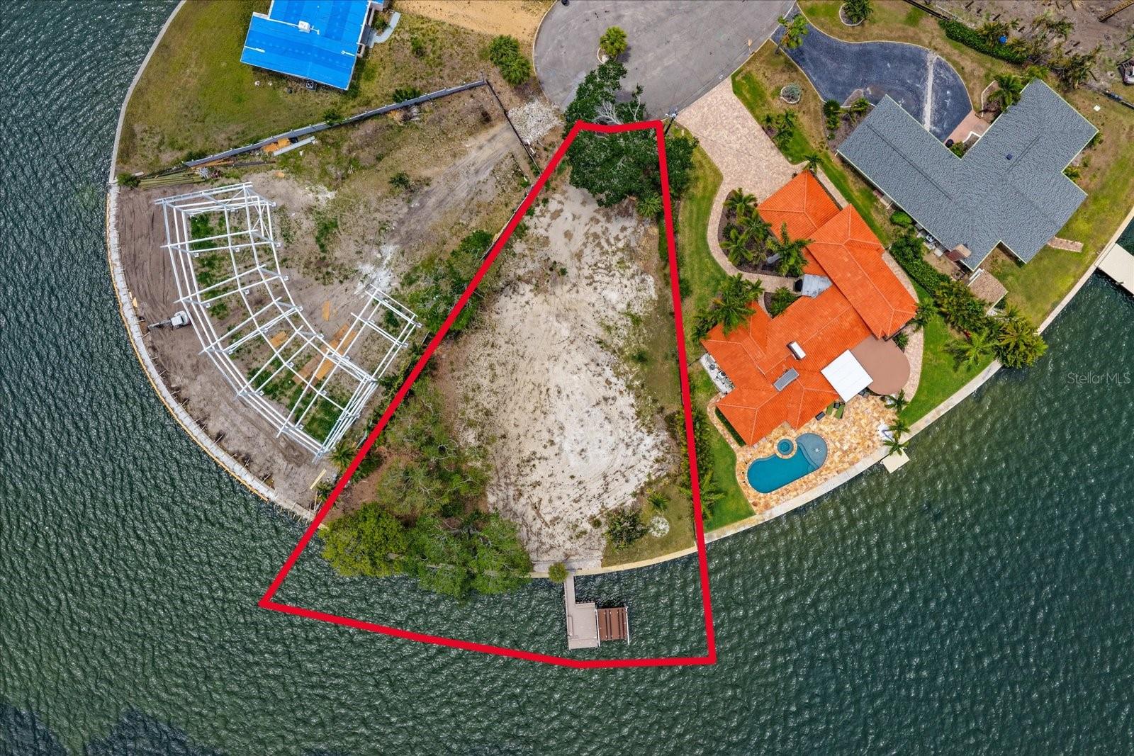 Set at the quiet end of an exclusive no-through street, 4838 Paradise Way S. represents a rare opportunity to create your spectacular waterfront home in one of St. Petersburg’s most desirable boating locations. An exceptional pie-shaped lot spans .35 acres and offers an impressive 160 feet of deep-water frontage, complete with newer composite dock with boat lift and jet ski platform, in place. Fish directly from your dock, and enjoy the dolphins playing in the surrounding waters, and relax in the your peaceful and private waterfront haven.
Facing southeast, the property is perfectly positioned to capture glorious morning sun across wide-open water views. The previous structure has been completely cleared, allowing for a seamless start to construction. Ready to design and build your custom waterfront estate, tailored to your vision and lifestyle. Please note there is an AI generated image of what a home COULD look like on the land. There is no building at this time, it is vacant land only.  All construction is subject to local planning permits and guidelines.
Despite its serene and secluded setting, the property is remarkably close to the energy and excitement of downtown St. Petersburg — just a 10-minute drive away, not much more by powerboat.  Enjoy the city’s vibrant cultural scene, renowned waterfront parks, acclaimed dining, boutique shopping, galleries, museums, festivals, open-air entertainment, and the iconic St. Pete Pier. The city’s famous murals, which adorn buildings throughout downtown, add to the unique artistic spirit that has made St. Petersburg one of Florida’s most sought-after coastal destinations. Coming in the near future is an expansion to the Old South East waterfront, promising further boat moorings, dining and entertainment venues to complement residential developments.
Come view this rare combination of tranquility, boating access, expansive waterfront, and proximity to one of Florida’s most dynamic downtowns.  Note: Be aware this is a freshly cleared parcel. Uneven surface conditions exist due to clearing. Proper footwear is recommended.Any Visitor to this vacant lot agree and acknowledge that they shall use due care in their entry upon the property and not undertake any act that may result in injury.