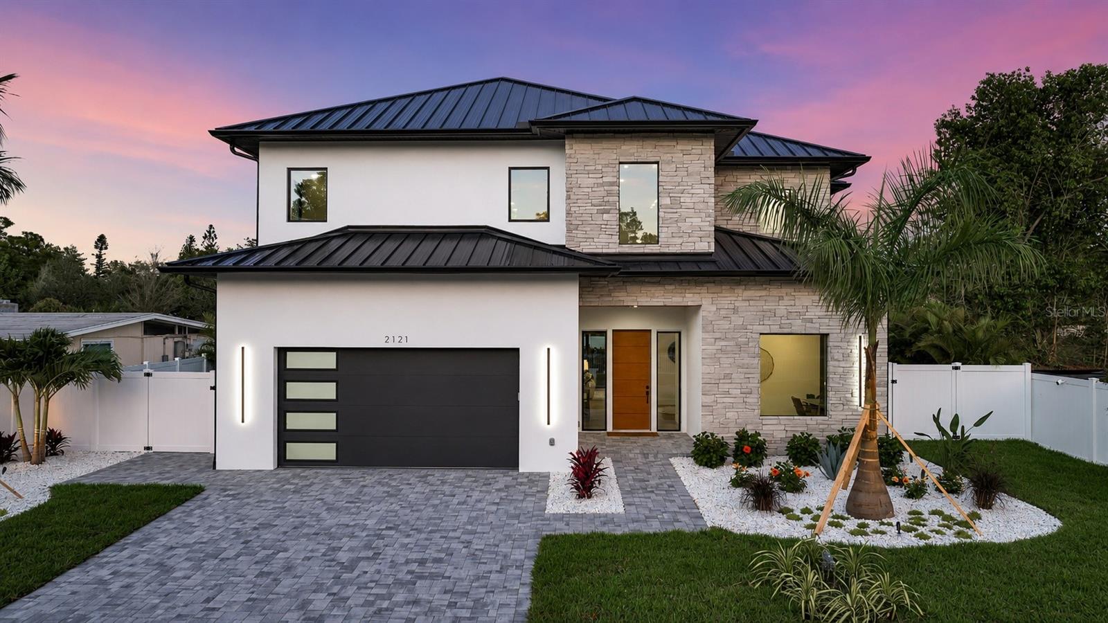 Not just another house but a carefully curated masterpiece by Segatto Property Solutions Inc. Come experience a blend of modern luxury, sophisticated design, and effortless Florida living in this stunning, newly completed custom residence. This move-in-ready, two-story block home offers four bedrooms and 4.5 baths plus an office, thoughtfully designed with impeccable attention to detail, soaring ceilings, and an open-concept layout ideal for everyday living and elevated entertaining. From the moment you enter, you’re greeted by 10-foot ceilings throughout, with dramatic 22-foot ceilings in the great room that create a grand, light-filled space. The office and primary suite also feature 12-foot ceilings, adding an extra layer of refinement and comfort. The designer kitchen is the heart of the home, showcasing quartz countertops, all Moen fixtures in bronze gold, and matte black, a premium KitchenAid appliance package, custom cabinetry, walk-in pantry, and an oversized island that flows seamlessly into the great room and dining areas. Expansive sliders open to the outdoor living space, delivering the ultimate indoor-outdoor lifestyle. Go outside to your fully fenced, private oasis featuring a heated saltwater pool, a fully equipped covered outdoor kitchen with grill and refrigerator, and an outdoor shower, ideal for entertaining or unwinding in total privacy. The first floor primary suite offers a spa-like retreat with luxurious finishes, generous space and a beautifully appointed bath, featuring dual shower heads, free-standing tub and an oversized walk-in closet. Upstairs, two additional en suites and a versatile loft area with a wet bar provide the ideal setting for a media room, lounge or guest retreat. Practicality meets luxury with a well-appointed first-floor laundry room featuring LG smart washer and dryer, additional built-in storage and a utility sink. Every detail of this home reflects quality craftsmanship and modern elegance, delivering the feel of a high-end model home without the wait. Ideally in Arlington Park, near shopping, dining, beaches and everything Sarasota has to offer, this exceptional home is ready for its first owners. Schedule your private showing today. Homes of this caliber, completed and move-in ready, are a rare opportunity.