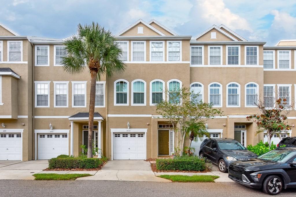 Move-in ready and beautifully positioned in the gated South Tampa community of Bayshore Pointe, this spacious 3-story townhome offers 3 bedrooms, 2 full bathrooms, 2 half bathrooms, 1,904 square feet, and a 1-car garage in one of Tampa’s most convenient locations. The first floor features a tile entryway, garage access, a half bath, and a flexible bonus room at the rear of the home complete with a closet housing the washer and dryer. This space is ideal for a home office, fitness area, guest space, playroom, or additional living area, with direct access to the covered back patio for easy indoor-outdoor living. On the second floor, the main living level feels open and inviting with laminate flooring, a comfortable family room, dual French doors leading to the porch, and a formal dining space overlooking the living area. The kitchen offers white cabinetry, gray countertops, stainless steel appliances, tile flooring, a pantry, an island with barstool seating, and an eat-in kitchen area that makes everyday meals and entertaining simple. A convenient half bath completes the second floor. Upstairs, the third floor includes a small loft-style landing that works perfectly as a desk nook or compact workstation. Bedrooms two and three feature carpet and share a full guest bathroom with a single vanity and shower/tub combination. The primary suite offers carpet, a ceiling fan, walk-in closet, and an ensuite bathroom with an extended vanity, soaking tub, walk-in shower, and tile flooring. Bayshore Pointe offers the privacy and comfort of a gated community with a virtual guard, low HOA fees, lush green spaces, ample guest parking, and resort-style amenities. The community pool and clubhouse are just steps away, the tennis court is a short walk, and residents enjoy access to a private community pier located just across from the gated entry. Located in the heart of South Tampa, this townhome provides quick access to Tampa International Airport, Downtown Tampa, Bayshore Boulevard, Cypress Point Park, MacDill Air Force Base, the Gandy Bridge to St. Petersburg, Tampa’s cruise ports, and some of Florida’s award-winning Gulf beaches. With generous living space, flexible rooms, desirable amenities, and a prime location, this Bayshore Pointe townhome is ready for its next owner.