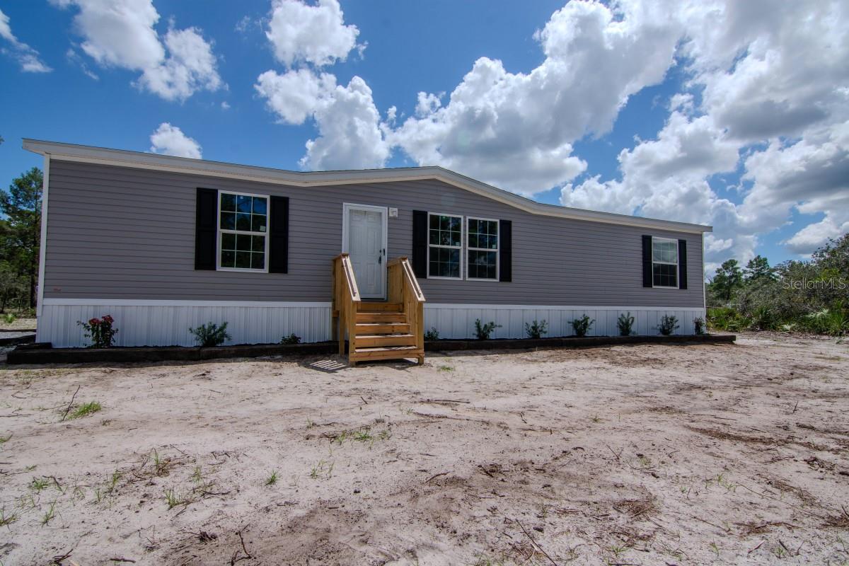 Brand New Manufactured Home on 2.07 Acres
Welcome to your perfect blend of modern comfort and wide-open space. This newly manufactured home sits on 2.07 private acres, offering room to grow, play, or simply enjoy the tranquility of country living—all while staying close to modern conveniences.
Inside, you’ll find 1,494 square feet of thoughtfully designed living space, featuring three spacious bedrooms and two full bathrooms. The open-concept layout includes a stylish kitchen with a center island, upgraded stainless steel appliances, and a brand-new washer and dryer, making this home completely move-in ready.
Step outside to your new 8'x10' deck, the perfect spot to relax and take in the peaceful surroundings. The property is partially wooded with thick, mature trees that can be cleared to suit your needs—ideal for adding a shop, garden, animal enclosures, or other structures.
Everything in this home is brand new, including the well, septic system with drain field, and electrical system. A freshly installed 300-foot gravel driveway leads to a large parking area, offering plenty of space for vehicles, RVs, trailers, or future expansion. Best of all, the property is not in a flood zone, giving you added peace of mind and flexibility for future improvements.
Whether you're starting fresh, downsizing, or just dreaming of more space, this turnkey home is ready to welcome you. Don’t miss the chance to enjoy freedom and serenity.
