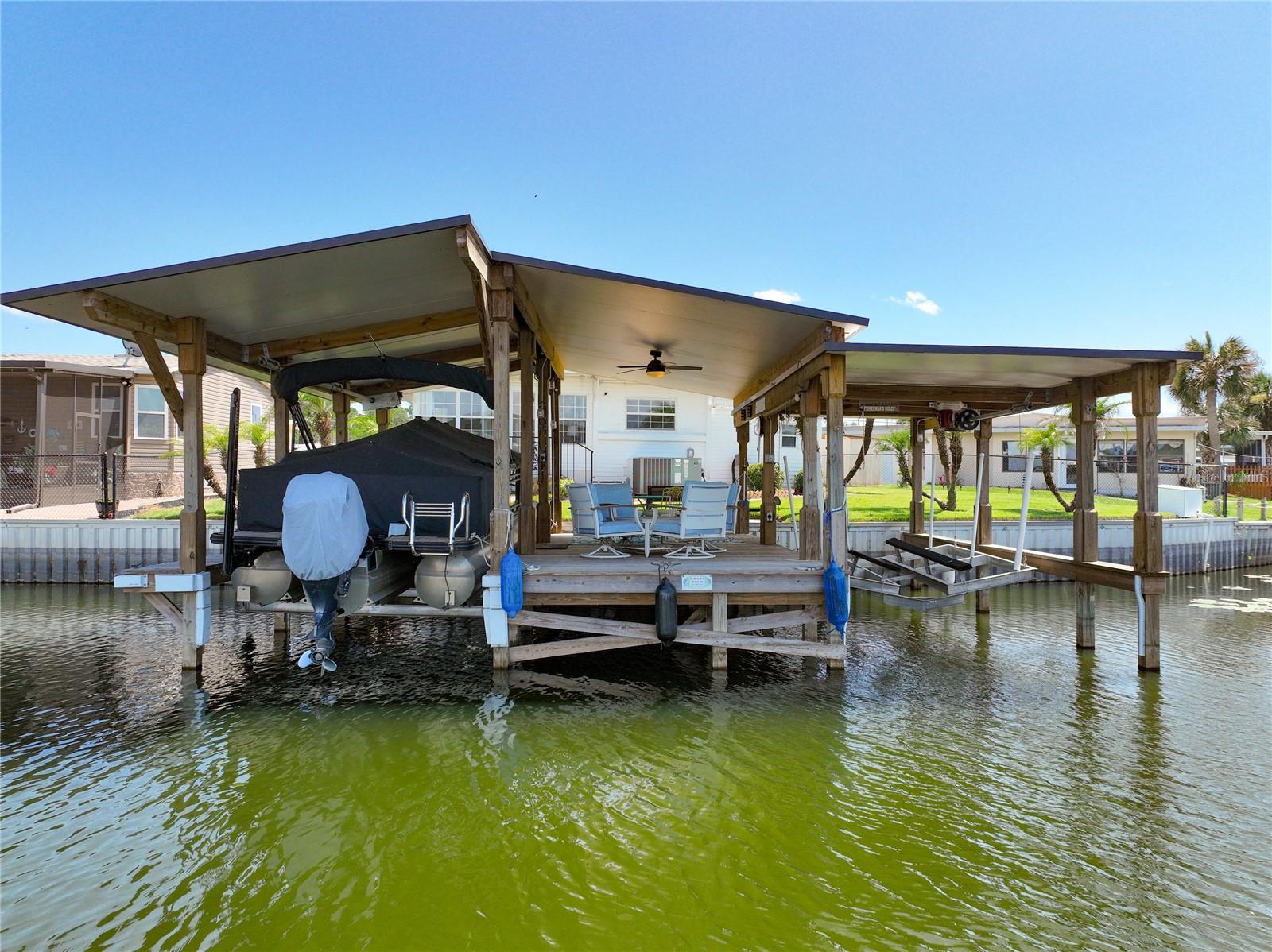 Discover the perfect blend of comfort and waterfront living with this well-maintained canal-front home in the heart of Tavares. Nestled on a quiet cul-de-sac with 75 feet of canal frontage and direct access to the Harris Chain of Lakes, this property is a boater's dream—and best of all, there is NO HOA and NO HOA fees.  The backyard is designed for enjoying Florida's outdoor lifestyle. The completely rebuilt dock features two covered boat lifts both 5,000 lb capacity recently replaced, a spacious covered entertaining deck, and new electrical service, creating the perfect setting for relaxing, hosting friends and family, or heading out for a day on the water. Cruise through the world-famous Dora Canal, enjoy waterfront dining, or spend the day exploring the Harris Chain of Lakes—all just minutes from your backyard.  Inside, the open floor plan offers comfortable living with beautiful canal views from the kitchen and main living areas. The spacious layout includes a generous primary suite with half bath, a comfortable guest bedroom, and ample storage throughout. Most of the home features insulated walls and ceilings for added energy efficiency. Recent improvements include a newly installed mini-split air conditioner in the guest bedroom and a supplemental window unit in the primary bedroom for enhanced comfort.  Outside, you'll also appreciate the two-car carport, workshop area, and additional storage space. Conveniently located in Tavares, you'll enjoy easy access to grocery stores, restaurants, shopping, and medical facilities. When you're ready for a change of scenery, Florida's east and west coast beaches are both within an easy drive.  Whether you're searching for a full-time residence, a seasonal retreat, or the ultimate waterfront getaway, this exceptional property offers the lifestyle you've been dreaming of. Don't miss this rare opportunity to own your own slice of paradise on the Harris Chain of Lakes. Call today to schedule your private tour!