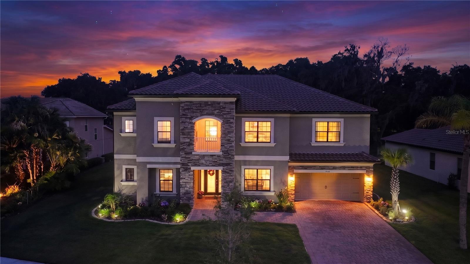 Once in a blue moon, a home comes along that feels less like a residence and more like a rare alignment of nature, serenity and soul.
At 1480 Beacon Drive, mornings begin beneath soaring bald eagles and evenings unfold under shimmering skies, with protected natural beauty, including the bald eagle nesting preserve directly behind the home. A backdrop few residences will ever know. The conservation setting ensures enduring privacy and extraordinary connection to nature for years to come. Cape Canaveral rocket launches can be seen streaking across the horizon.offering not only natural beauty, but a front-row seat to wonder itself.Framed by a commanding stacked-stone architectural tower façade with timeless Mediterranean character, an immediate statement of warmth, strength &  refinement.Thoughtfully upgraded throughout, the home blends sophisticated comfort with modern convenience. Outdoors, a heated saltwater pool & spa, complete with Baja Beach sun shelf, bubbler features, water jets, ambient lighting, Pentair Intelli automation, screened enclosure, lush landscaping, plumbing/electrical in place for a future outdoor kitchen.Inside, upgraded porcelain tile flows through beautifully designed living spaces anchored by a soaring two-story great room overlooked by the upstairs catwalk, iron spindle railings. 8' interior doors, Office French Doors, custom illuminated lounge cabinetry & a designer fireplace elevate the home’s architectural character.The chef’s kitchen was designed for gathering and functionality, featuring two independent islands, eat-in breakfast area, butler’s pantry, level 5 cabinetry, GE Café induction appliances, double convection ovens, pot filler, coffee station, elegant Viatera Intermezzo quartz & Bianco Antico granite countertops, pull-out shelving, integrated waste storage, extensive pantry space, and valuable under-stair storage.The primary suite offers a spa-inspired retreat with seamless glass shower enclosure, spa tub, upgraded finishes & customized storage solutions. Custom Closets by Design enhance the office, primary closets, laundry room, and theater room. The dedicated home theater features built ins, custom lighting, builtins & upgraded surround sound.Important enhancements include Taylor Morrison’s LiveWell™ Healthy Home package with air filtration, low-VOC finishes, enhanced ventilation & smart environmental controls. Further upgrades include insulated garage doors, epoxy-coated 3-car garage flooring, MyQ WiFi-enabled garage system with Amazon delivery access, widened driveway, Rain Bird WiFi irrigation, Ring security, cameras, Hotwire Fusion 1Gb internet, gutters, blinds, ceiling fans, and integrated smart-home conveniences throughout.Beyond your backyard lies the lifestyle of Bellalago — a guard-gated lakefront community on Lake Toho where every day feels like a resort escape. Residents enjoy waterfront dining, scenic nature trails, resort pools, fitness center, tennis, pickleball, sand volleyball, splash pad, fishing pier, and private boat ramp access, and boat lifts, all conveniently close to shopping, healthcare, and Disney. Rarely does a home so effortlessly combine luxury, tranquility, technology, community, and the extraordinary beauty of the natural world. Come experience the rare magic of 1480 Beacon Drive for yourself — where soaring skies, peaceful living, and elevated design create a home truly written in the stars. *refrigerator, wine fridge, whole home water softener system does not convey