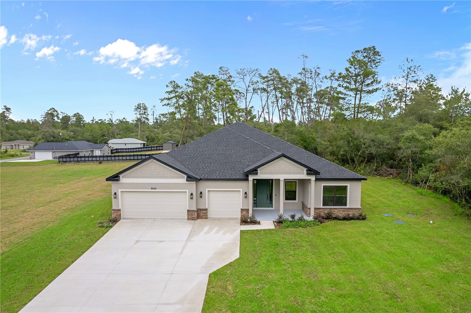 Welcome to 8065 N Dothan Drive! Construction is complete and is move-in ready. This home has a modern design and plenty of space. Sitting on nearly an acre of land, giving you plenty of privacy, plus room for a workshop, pool, or exterior garage. The open floor plan features 4 bedrooms, 3 full bathrooms, and a 3-car garage.  Upgraded finishes throughout the home include quartz countertops, 42 inch shaker cabinets, stainless steel appliances, ring doorbell, primary bedroom suite, washer & dryer, covered lanai, and luxury vinyl plank flooring in every room. The upgraded 9 foot, 4 inch ceilings make this home feel open and spacious. Located just 1.5 hours from Orlando and Tampa, with local shopping and dining only 15 minutes away. With no HOA, you have the freedom to personalize the space to fit your needs. This home comes with a builder 2/10 warranty.