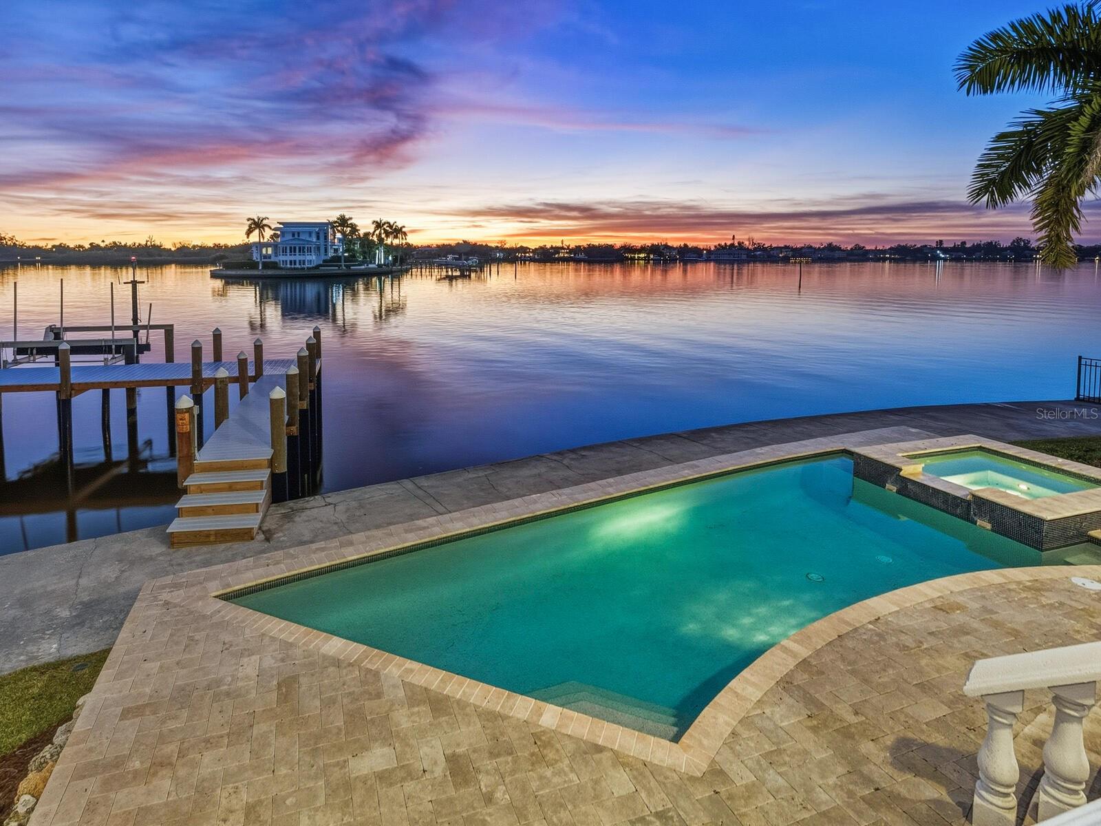 Under contract-accepting backup offers. Substantial price change, $750,000 less. Positioned at the end of a quiet cul-de-sac, this exceptional bayfront residence is a haven for boaters and sunset enthusiasts alike. Set directly at end of a peninsula on the Intracoastal Waterway, the home enjoys sweeping open-water views and effortless access to the Gulf, while capturing breathtaking, mango-hued sunsets that paint the sky each evening. Designed to fully embrace its remarkable waterfront setting, the home offers gracious formal living and dining rooms alongside a warm and inviting family room with fireplace, seamlessly open to a chef’s kitchen appointed with high-end appliances and generous workspace, ideal for entertaining against a backdrop of ever-changing bay views. Walls of glass invite the outdoors in, opening to a terrace-style balcony overlooking the water, where evenings unfold with glowing skies and gentle bay breezes. From the terrace-style balcony, the home transitions naturally down to a resort-style bayfront heated pool and spa, and expansive waterfront yard, creating a stunning setting for alfresco dining, relaxation and waterfront gatherings. Boaters will appreciate the private bayfront dock and lift, protected Intracoastal waters ideal for kayaking and paddleboarding, and daily encounters with dolphins and abundant marine life, all enjoyed right from the comfort of home. The primary bedroom suite encompasses the entire top floor, creating a private sanctuary above it all. Thoughtfully designed for tranquility and privacy, the suite features expansive bay views, a private balcony positioned for sunset watching and a spa-inspired bath designed for relaxation. This serene retreat offers an owner’s haven, secluded, elevated, and immersed in the beauty of the surrounding water and sky. Offering four bedrooms, four full baths and three additional half baths, the residence provides exceptional comfort and flexibility for family and guests. A three-car garage and a one-year-old metal roof complete the home, balancing refined elegance with everyday functionality. Quietly tucked away in Sarasota’s sought-after Coral Cove neighborhood, yet moments from world-famous Siesta Beach and Sarasota’s cultural, dining, and coastal attractions, this exceptional estate delivers an extraordinary waterfront lifestyle, where boating, sunsets and refined living come together in harmony. Tranquil, elegant and undeniably special.