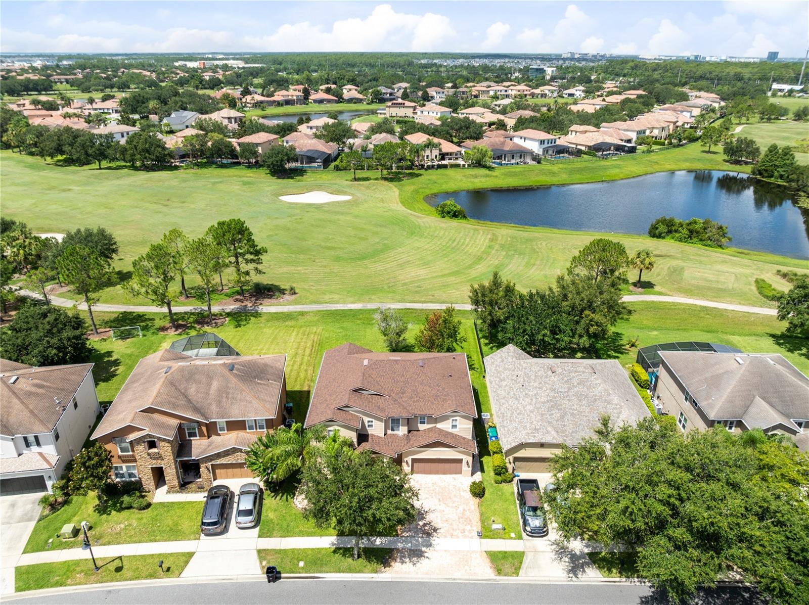 Virtually Staged. Framed by sweeping golf course views in the guard-gated Eagle Creek community, this distinguished Lake Nona residence pairs generous proportions with a refined, light-filled interior. Beyond the brick-paver drive and mature landscaping, the 3,566-square-foot floor plan unfolds through formal living and dining spaces into an expansive gathering area designed for both elegant entertaining and relaxed everyday living. Laminate flooring creates a polished, easy-care foundation across the first floor, while oversized windows draw in natural light and showcase the home’s open setting. At the heart of the residence, the kitchen features white cabinetry, granite countertops, stainless steel appliances, a closet pantry, and a broad breakfast bar overlooking the family room and breakfast nook. Sliding glass doors extend the living space to a brick-paver patio and an exceptionally deep backyard, where unobstructed golf course vistas create an impressive backdrop for outdoor dining, entertaining, or a future private retreat. A first-floor bedroom with an adjacent full bath offers a gracious arrangement for guests, multigenerational living, or a private office. Upstairs, real wood flooring leads to a spacious loft and four well-proportioned bedrooms. The primary suite is a true retreat, capturing tranquil golf views and offering a walk-in closet plus an en-suite bath with dual sinks, a soaking tub, and a separate shower. Ceiling fans, updated baths, a two-car garage, and a cohesive neutral palette complete the home. Eagle Creek offers a resort-inspired lifestyle with community pools, fitness facilities, tennis courts, playgrounds, a dog park, sports fields, and clubhouse dining—all moments from Lake Nona Town Center, Medical City, the VA Medical Center, USTA National Campus, Orlando International Airport, SR-417, and SR-528. Experience elevated golf-front living in one of Lake Nona’s most desirable gated communities.