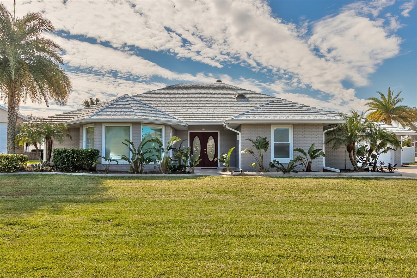 Spruce Creek Fly-In hangar home with resort-style pool and patio! This beautiful home offers excellent indoor and outdoor living and entertaining areas. Featuring an open-concept kitchen with granite counters, soft close wood cabinets, skylights, stainless appliances, a breakfast bar, and an informal eating area with easy access to the formal dining room and living room with fireplace, wet bar, and wine cooler. The master suite has direct access to the outdoor hot tub, spacious patio, and pool. The master bathroom boasts a large soaking tub, walk-in shower, his and her walk-in closets, and a marble-topped vanity with dual sinks. The split floor plan offers privacy with two bedrooms including sizeable walk-in closets and full bath. A family room/den for relaxing opens to the paver covered patio with a hot tub, a pool area, and the hangar. The hangar is 43' x 38'  and is tiled, climate controlled, and has an electric motorized bi-fold insulated door measures 40'W x 10'8'' H to accommodate planes, cars, or any other big toys. With its kitchen nook, refrigerator, and workbench the hanger is perfect for storing or building the toys associated with hanger home living. Property includes some furniture.  Improvements include new A/C (2022), plantation shutters, metal roof, and a tiled hanger floor making this house more special. Spruce Creek Fly-In is a gated community with 24/7 security. Located close to shopping, restaurants, Port Orange schools, interstate highways & recreation areas, optional country club memberships, an on-site restaurant, hair salon, children's playground, and a private airport with a 4,000’ paved runway. ;Water: City