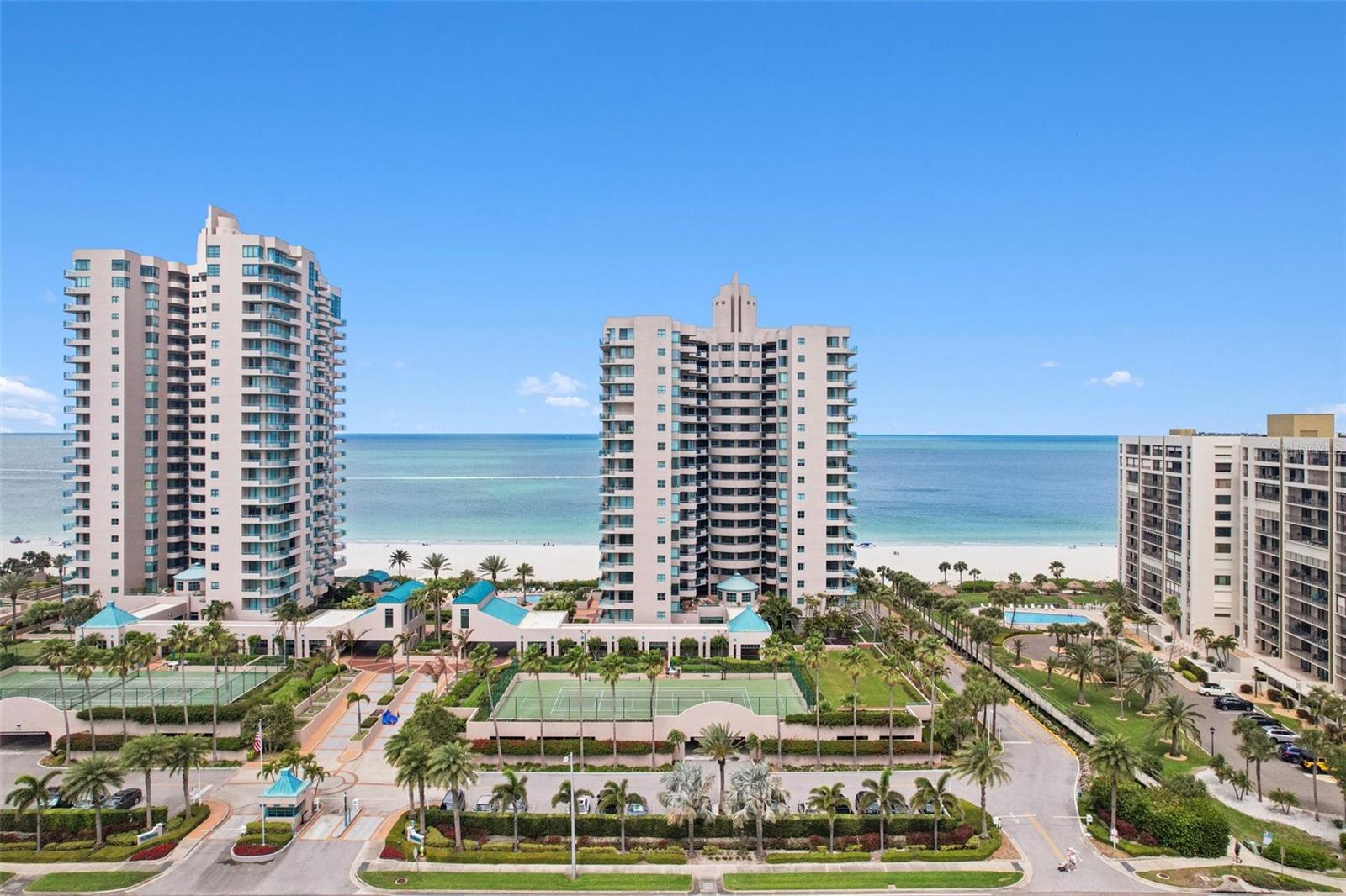 Experience a level of coastal living and entertaining that is simply unmatched. Offered for the first time, this 3-bedroom, 2.5-bath residence with a deeded two-car garage at Ultimar I was the developer’s personal direct beach access ‘penthouse’—meticulously maintained and never before available to the public. Enjoy unobstructed ocean views and private terrace living, just steps above the sand. Residence #202 stands alone as a private corner residence with panoramic beach vistas and an exclusive entryway. The high ceilings and its massive wraparound limestone terrace—the largest and most expansive private outdoor space in Ultimar I —defines the estate with access through a private vestibule. This seamless extension of the home flows directly from the kitchen, main living areas, and primary suite, creating an effortless indoor-outdoor sanctuary perfect for grand entertaining or quiet evenings under the stars. Floor-to-ceiling glass frames sweeping Gulf views from sunrise to sunset, while the terrace itself serves as an elevated outdoor living room for sunset soirées, intimate dinners, and skyline views of downtown Clearwater Beach. The design provides all the privacy, scale, and attributes of a private beachfront residence—without any of the maintenance, upkeep, or operational work. Enhancing this extraordinary setting even further is direct private beach access via your own architectural staircase, leading straight from the expansive terrace to the pristine, sugar-white sands of Sand Key. Step from your private retreat onto the shoreline with complete privacy and ease. Set within the guard-gated enclave of Ultimar I, residents enjoy resort-style amenities, including three heated pools, Har-Tru tennis and pickleball courts, a state-of-the-art fitness center with steam and sauna, and beautifully landscaped grounds with a fire pit, putting green, croquet lawn, and grilling areas. Sand Key delivers serene exclusivity and peaceful beachfront living at its finest. This is a true “one-of-one” opportunity—combining the building’s largest private outdoor footprint, rare high ceilings, direct private beach staircase access, and single-developer ownership in a setting designed for effortless coastal living and entertaining at the highest level.