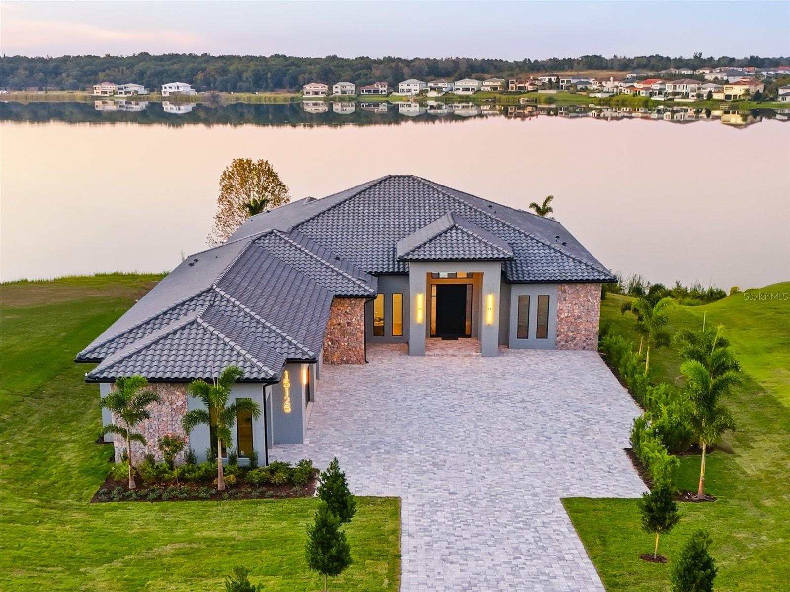 A contemporary Mediterranean lakefront masterpiece, this single-story, fully linear residence redefines sophistication in every detail. Its elegant façade, stone accents, and sweeping paver driveway introduce an extraordinary interior with soaring ceilings, custom millwork, and refined European-inspired design. Every bedroom features luxury custom-built closets, while the designer kitchen and fully furnished custom office elevate the home’s exclusivity.

Expansive open spaces are bathed in natural light, capturing breathtaking panoramic views of the water. Floor-to-ceiling retractable glass walls allow you to enjoy both the sunrise and the most unforgettable sunsets from inside the home or the outdoor oasis. The exterior is truly cinematic, showcasing a sculptural infinity-edge pool in deep blue tile, elevated spa, spacious deck, and fire pit.

Living in Bella Collina means more than simply owning a beautiful home—it is an invitation to an extraordinary lifestyle. Residents enjoy world-class amenities, including fine dining, a state-of-the-art fitness center, tennis courts, a resort-style pool complex, and the acclaimed 18-hole championship golf course designed by Sir Nick Faldo.

A rare, sophisticated, and incomparable Mediterranean residence for those seeking the very best Bella Collina has.