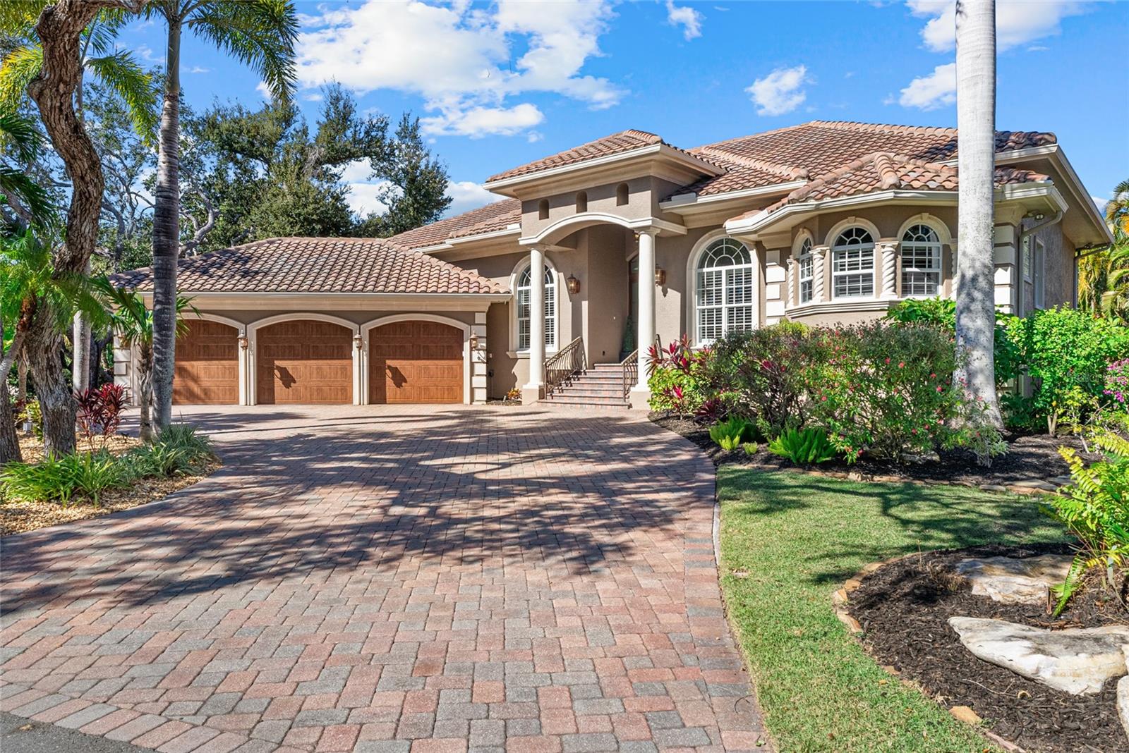 A spectacular offering on one of Siesta Key’s most coveted streets, this stunning canal-front residence on Tremont Street represents a truly special opportunity to own a home that seamlessly blends boating, timeless island charm, and refined coastal living. Tucked beneath mature trees in a quiet, established enclave known for its old Siesta character, the property offers private canal frontage with a lift and a short, easy boat ride to the Intracoastal Waterway, all just minutes from Siesta Village and the world-renowned white sands of Siesta Beach. Homes of this caliber and setting are seldom available and must be experienced in person to be fully appreciated.
Offering 4,194 square feet under air, the thoughtfully designed floor plan is both impressive and highly livable, ideal for full time residents and seasonal owners alike. Soaring ceilings, abundant natural light, and quality craftsmanship define the interior. The main floor primary suite is complemented by additional bedrooms on the main level, providing the ease of one level living, while the second floor offers a spacious guest suite and bonus room with peaceful views of the pool and canal.
Exceptional indoor-outdoor living is at the heart of the home. Multiple pocketing sliding glass doors open wide to an expansive covered and fully screened lanai, creating a seamless connection between interior and exterior spaces. The outdoor living area is generous in scale and designed for entertaining, featuring a heated pool and spa, summer kitchen, gas fireplace, and multiple areas for dining and relaxation. The large screened layout allows you to comfortably enjoy outdoor living year round, regardless of the weather.
Lush tropical landscaping enhances privacy and creates a tranquil island setting, while boating enthusiasts will appreciate the private lift and convenient access to open water. Impact-rated windows and doors, a generator, and a three-car garage provide peace of mind and everyday practicality.
611 Tremont Street combines location, boating, and lifestyle in a way few homes can. If you have been waiting for an exceptional Siesta Key property in one of the island’s most desirable neighborhoods, this is one you should see in person before it sells.