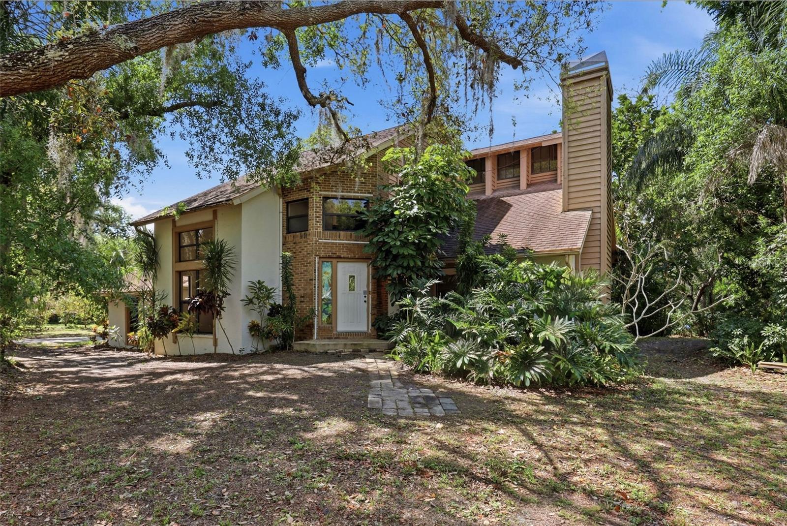 Tucked away off Clark Road in Sarasota, this extraordinary property is more than a home, it’s a private sanctuary for those who value space, serenity, and possibility. Set on just over six lush acres with a winding, tree-lined driveway, the experience begins the moment you arrive.
With over 400 mature trees, this one-of-a-kind place feels like your own botanical retreat. A rich variety of avocado, mango, eucalyptus, jacaranda, macadamia, lychee, starfruit, jackfruit, and Thai jujube trees create a vibrant, ever-changing landscape filled with color, texture, and life. This setting is both inspiring and rare. In the southwest corner of the property lies a picturesque one-acre private lake, offering tranquil water views and a sense of calm that’s hard to find. The expansive grounds provide incredible flexibility for those seeking a private retreat, a multi-use property, or simply room to breathe and grow. The two-story residence is light and bright, blending indoor and outdoor living seamlessly. Strategically placed windows invite natural light to pour in while capturing beautiful views of the surrounding landscape from nearly every room. The result is a home that feels open, airy, and deeply connected to its environment. Every corner of this property has been designed to embrace the outdoors and enhance the sense of privacy and escape. One of the most compelling aspects of this offering is the freedom it provides. With no deed restrictions, NO CDD fees, and NO HOA, you have the flexibility to truly make this property your own. Bring your RV, boat, trailers, and toys—there’s ample space and no limitations holding you back. Properties like this are exceptionally rare in Sarasota—a peaceful, private oasis with acreage, natural beauty, and unlimited potential, all within reach of the area’s renowned amenities, beaches, and lifestyle. Located 7 short minutes away from I-75 and just 25 minutes from the sugar soft sands of Siesta Key. This is not just a place to live—it’s a place to create, to unwind, and to experience Florida in its most authentic and inspiring form. As Mark Twain once said, “Buy land, they're not making it anymore.”