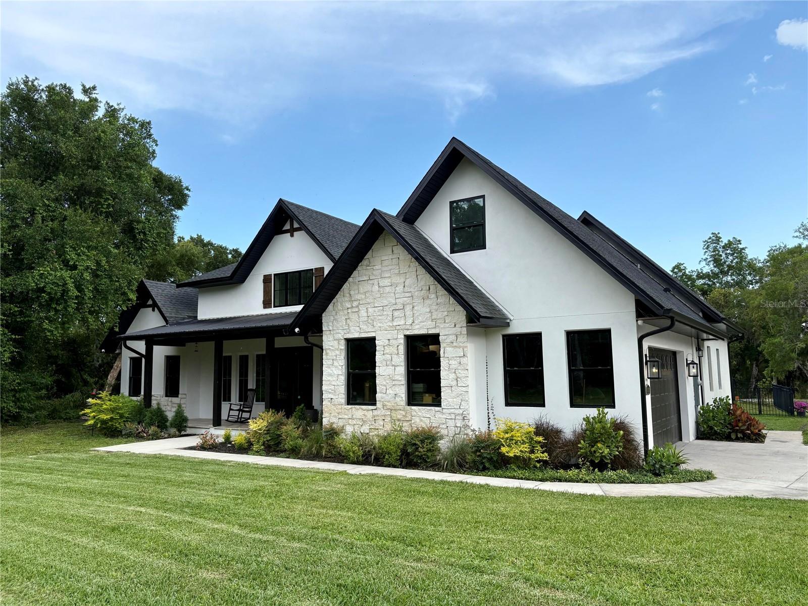 Welcome to your private waterfront paradise! This stunning 4-bedroom, 4-bath estate sits on 5 beautiful acres with 200 feet of Spruce Creek waterfront, offering breathtaking views, privacy, and direct access to the water. The property features a large private dock with two boat lifts, excellent for water activities. Designed for both entertaining and everyday living, the home showcases soaring ceilings and a spacious open floor plan filled with natural light. The chef's kitchen includes a walk-in pantry and ample prep space, well-suited for hosting gatherings or preparing family meals. Movie nights and game days are enhanced by the custom home theater right at home. Step outside to a resort-style retreat with a sparkling pool, pergola, and outdoor fireplace, creating a serene space for relaxing evenings or hosting gatherings while enjoying the waterfront views. The property also includes a fully equipped barn with flexible space for horses, hobbies, a workshop, or additional storage.

An in-law suite with its own private bathroom and kitchen provides convenient accommodations for guests, extended family, or multigenerational living. Nature lovers will appreciate the abundant wildlife and serene surroundings, all while enjoying the confidence of a property that is not in a flood zone. A gated entry, oversized garage, and lush landscaping complete this exceptional estate. Despite its private setting, this remarkable property is just minutes from shops, dining, and top-rated schools, providing a balanced combination of seclusion and convenience. This rare Spruce Creek waterfront estate combines luxury, privacy, and outdoor living at its finest.