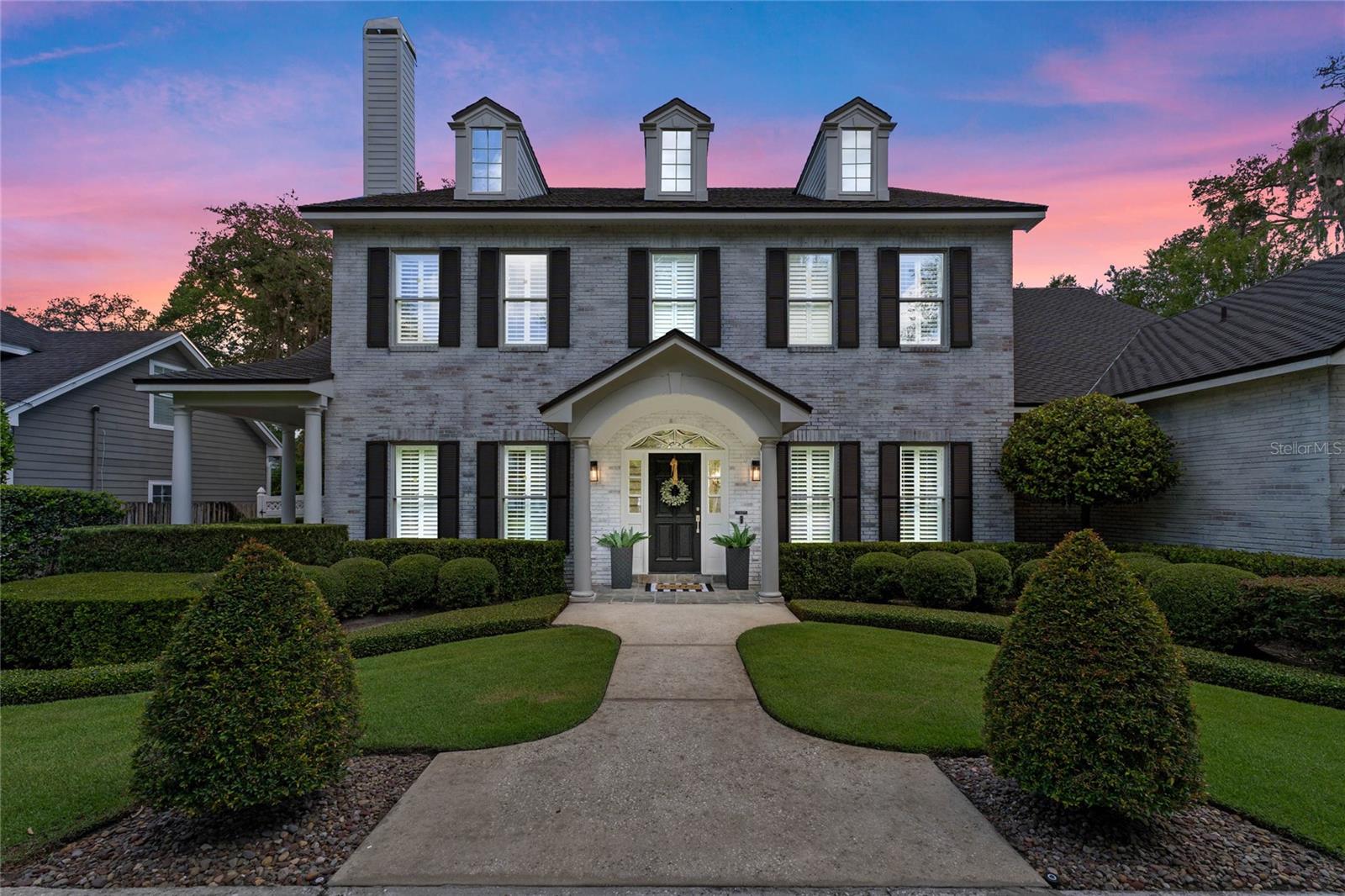 Welcome to this renovated traditional home, ideally situated on a corner lot in one of the most desirable neighborhoods in all of Central Florida. This charming, white-washed brick exterior Winter Park home offers everything a family could need. This two-story, 3 car garage, residence showcases the finest upgrades and provides an unparalleled living experience. As you enter the front door, the first floor welcomes you with a formal dining room that provides the perfect setting for entertaining guests with a custom-built wine display at arm's reach. Conversely, you also have an office that doubles as a sitting room with an exterior door leading to a charming cigar porch. As you continue down the hall, you enter an elegant living room featuring a gas fireplace, custom built-ins, and accordion stacking doors that open to a picturesque outdoor living area. The large chef's kitchen is equipped with a gas cooktop, farm sink, stainless appliances, quartz countertops, a butler's pantry, lots of cabinet storage, and a breakfast nook overlooking the pool. Opposite the kitchen, you have the first-floor primary bedroom with custom built-in closets and a large bathroom. Venture upstairs through one of the two staircases to an additional four bedrooms, three full bathrooms, and a bonus/theatre room, including two oversized storage closets that can be multifunctional. This is an excellent house for entertaining and enjoying the Florida sunshine with the expansive backyard, where you'll find a large pool, a covered sitting area, and a fully equipped summer kitchen with a grill, Green Egg, sink, and fridge. Located in the premier neighborhood of Winter Park, this home is minutes from Park Avenue, with numerous top restaurants, shops, and yearly events to enjoy. You can also easily access major roadways, top golf clubs, and tennis facilities such as the Winter Park Racquet Club and Interlachen Golf and Country Club. This home is zoned for highly rated Winter Park schools, including Dommerich Elementary, Maitland Middle, and Winter Park High School. This exquisite residence epitomizes elegant living in a prime location. Don't miss the opportunity to make this stunning home your own.
