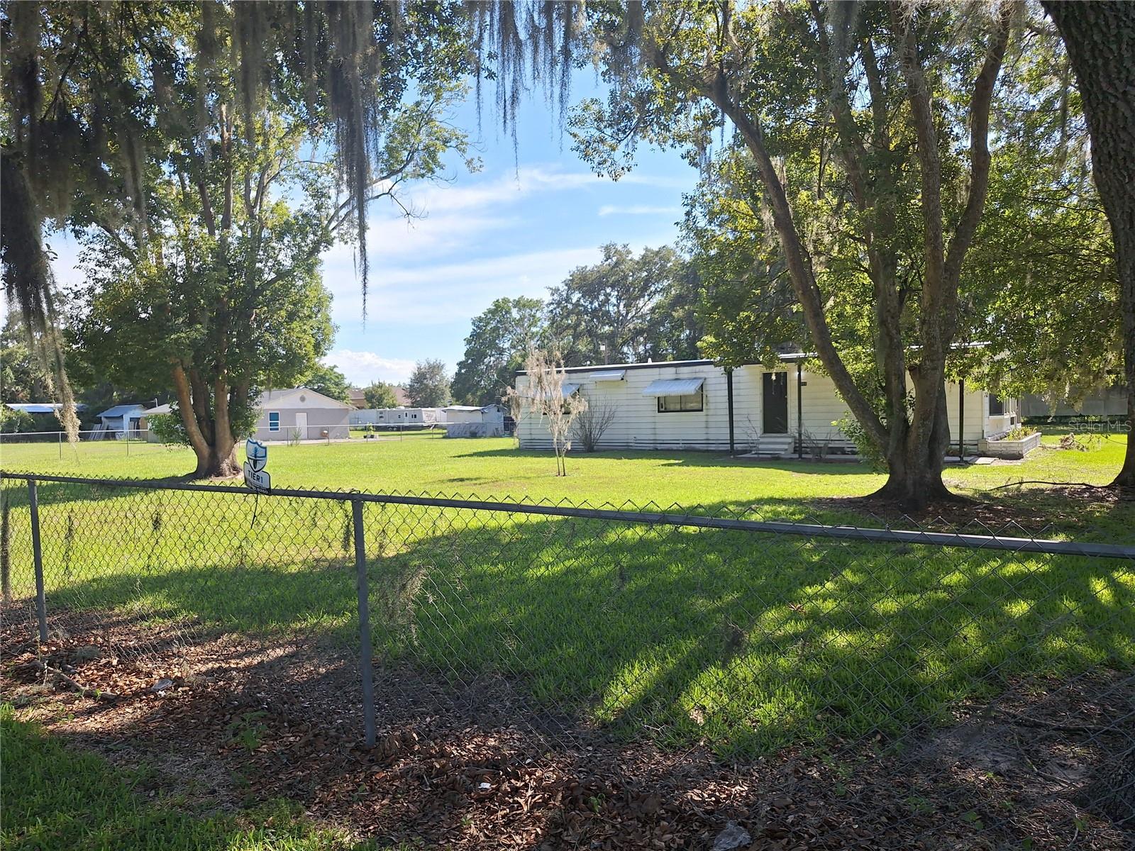 Great location on an acre. ALL fenced too ! Smaller dog ok ! Actual 4 bed rooms and small open area office desk location could work. HUGE Lani all screened in ! Has been Air B&B now only going to be 1 year lease but it is still furnished if want it! Will sell you the furniture very cheap as seen if want it ... ...Or will take away furnishings. And has central air an heat and has county water! Cute kitchen with nice appliances and lg dinning area off comfortable living room. All vinyl plank flooring throughout! This will not last and with HUGE screened lani to enjoy ! Cute country yet close to everything you need near by. No HOA just peace and quiet on an acre. Will not last pet? Ok but no more than 2 small dogs allowed.