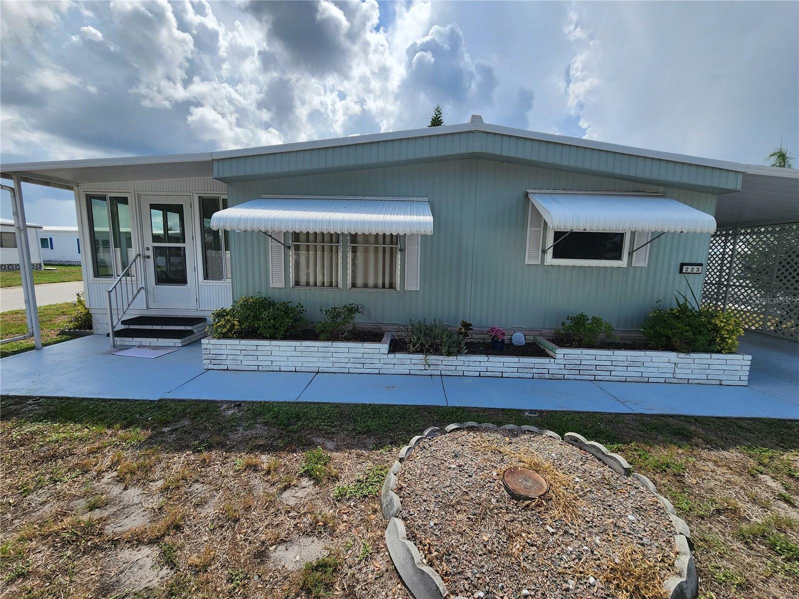 STOP PAYING LOT RENT! Here's your chance to own your slice of paradise in the highly desirable Palm Lake Estates 55+ community! This beautifully maintained, furnished home sits on a premium corner lot on a peaceful street and offers the affordable Florida lifestyle buyers are searching for. From the moment you arrive, you'll appreciate the pride of ownership. Inside, you'll find bright, inviting living spaces with easy-care flooring, updated windows throughout most of the home, abundant storage, spacious walk-in closets, and a comfortable glassed-in Florida room that's perfect for relaxing with your morning coffee, or entertaining family and friends. The guest bath features convenient double sinks, while the updated vapor barrier and replaced subflooring throughout most of the home provide added peace of mind. A generous two-car carport completes the package. The best part? NO LOT RENT! The low monthly maintenance fee includes water, sewer, trash, cable, internet, an on-site manager, clubhouse, and a sparkling community pool—giving you more time to enjoy life and less time worrying about expenses. And the location is hard to beat! You're just minutes from the sugar-sand beaches of Anna Maria Island, shopping, restaurants, medical facilities, golf, entertainment, and nearby airports. Whether you're looking for a full-time residence or the perfect winter escape, this home delivers outstanding value in one of the area's most popular 55+ communities.
