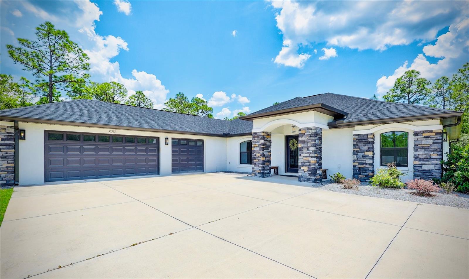 One or more photo(s) has been virtually staged. Welcome to your own private retreat in Weeki Wachee! Built in 2022 by Pastore Custom Builders, this stunning 3 bedroom, 3 bathroom, 3 car garage, pool home sits on a peaceful 1-acre lot surrounded by natural beauty and tranquility. From the moment you arrive, the striking stone-accented exterior and oversized driveway set the tone for what awaits inside.

Step through the elegant double-door entry into a bright, open-concept floorplan featuring soaring ceilings, luxury vinyl plank flooring throughout, and seamless indoor-outdoor living. Expansive pocket sliding glass doors fully open to the screened lanai, creating the ultimate entertaining space and effortlessly blending indoor comfort with outdoor living.

The gourmet kitchen is truly the heart of the home, showcasing gorgeous quartz countertops, a massive 12-foot island, Café smart appliances, abundant cabinetry, designer finishes, and an incredible layout perfect for both everyday living and entertaining.

The split-bedroom floorplan offers privacy, with the luxurious primary suite tucked away from the additional bedrooms. Enjoy private pool access, custom dual walk-in closets with built-ins, and a spa-inspired bathroom retreat designed for relaxation. Additional highlights include a mudroom with a convenient utility sink and separate entrance, epoxy garage floors, and the peace of mind that comes with newer construction and major systems.

Outside, enjoy your resort-style screened saltwater pool with an oversized paver patio, and endless space to relax, entertain, and soak in the peaceful natural surroundings. 

Bring all your toys as this property offers the privacy and freedom you’ve been searching for while still being conveniently located near shopping, dining, and the Gulf Coast’s outdoor attractions.

Move-in ready and designed to embrace Florida living, this exceptional property is the perfect place to call home! Schedule your private showing today!
