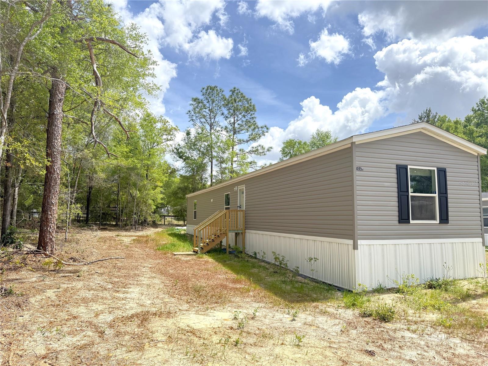 Why Rent? When you can own this *NEW* 3/2 singlewide! NO HOA!! Split plan with carpet in the Bedrooms & Living Room. Amana Refrigerator, Stove & Dishwasher come with this home. Laundry Room is conveniently located next to the Kitchen. The Primary Bedroom has an ensuite Bathroom with a one-piece fiberglass shower. HVAC ducks and Vents are in the ceiling. Recessed ceiling LED lighting throughout home. This property has been cleared for you and has new Well & Septic. If you need help with Closing Costs the Seller will negotiate. 10 minutes to Williston. Centrally located with about a 30-minute drive to Gainesville, Ocala or Chiefland. Williston is Growing with soon to open.... Aldi Grocery Store, WAWA Gas Station & Ellianos Coffee