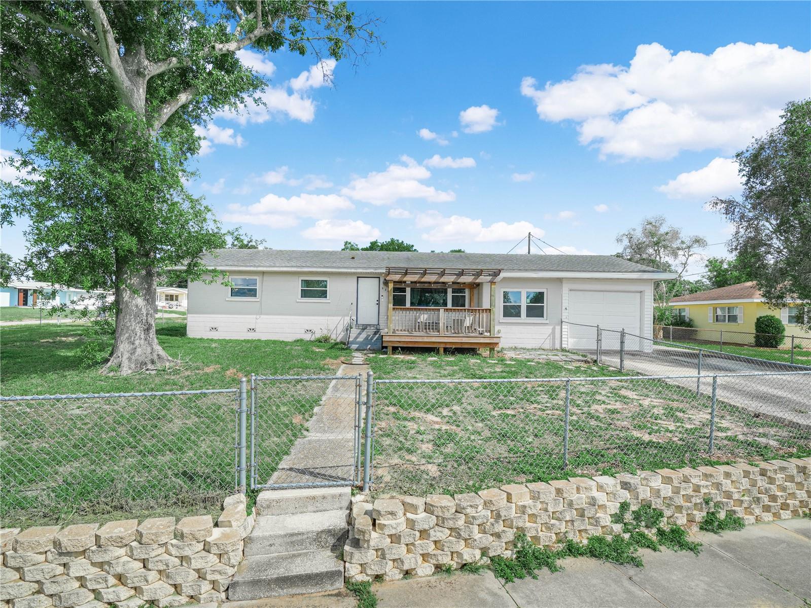 This 3/2/1 concrete block house sits on a corner lot with a fenced yard.  A deck was added at the front for outdoor enjoyment and a view of Lake Belle. Upon entering the home you'll notice the beautiful wood flooring in the spacious living room.  Kitchen has lots of counter space, a desk nook, breakfast nook and solid wood cabinets, plus comes with all the appliances.  The large separate dining room is perfect for holiday meals for the entire family.  The owners suite has an ensuite bathroom with a tub and shower combo that has a luxurious rainfall shower, while the guest bathroom has a tub and shower combo and a vanity with dual sinks.  The one-car garage has an electric garage door for your convenience, and the large adjacent laundry room comes complete with a washer and dryer.  Upgrades made within the last two years include a new HVAC, new double paned windows, new front door, new drain field and new insulation was blown into the attic for added comfort.  With all this home has to offer, it won't last long, so call now to schedule your private tour.