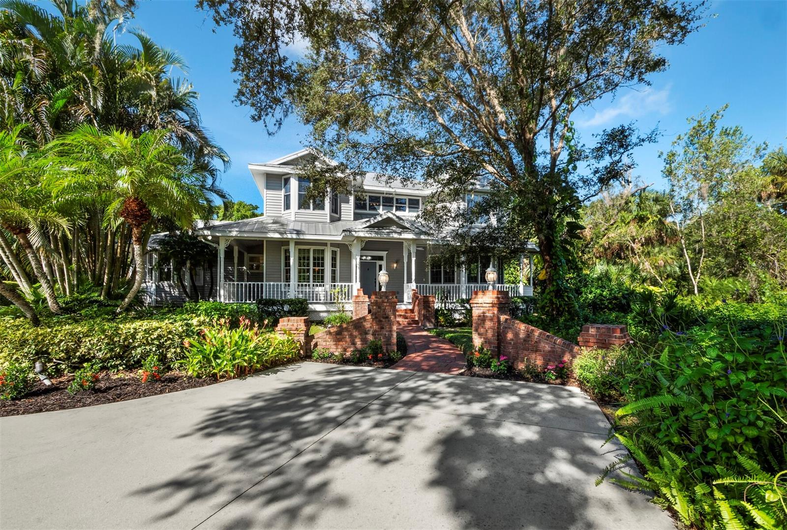 Welcome to the charming and secluded 50-home subdivision of Ashley in Sarasota where serenity meets sophistication. This stunning 4-bedroom, 3.5-bathroom sanctuary is nestled on a sprawling 1.1-acre lot ensconced by mature, verdant foliage, creating a picturesque, park-like setting. Privacy is paramount here, with a long driveway leading to the tucked-away residence which backs up to a wooded preserve. With no rear neighbors in sight, this residence ensures a sense of seclusion and solitude. This home features a classic metal roof, complemented by a charming brick pathway leading to the front door. The wrap-around front porch invites you to savor the tranquil surroundings, while the fully fenced backyard, complete with a gazebo, offers a private retreat for leisure and entertainment. Step into the heart of the property, where a large covered and screened lanai entices you to unwind in style. You will find a saltwater pool and spa equipped with an in-floor cleaning system, bench seating ledges, and a soothing stone fountain, creating a haven for both relaxation and recreation. Inside, the interior exudes elegance with hardwood flooring and a wood staircase, while 9-foot ceilings amplify the sense of space and airiness. Notice the intricate trim details, including wood door and window moldings adorned with bullseye rosette corner trim throughout, creating an atmosphere of refined luxury. This home offers versatile living spaces, including a sun-drenched living room ideal for a home office or a bonus room, a formal dining room featuring an octagon tray ceiling and chair railing, and a family room seamlessly connected to the kitchen, highlighted by a gas fireplace and French doors that open onto the lanai and pool area. The spacious kitchen is a culinary enthusiast's delight, complete with a center island featuring a breakfast bar and brand-new stainless-steel GE appliances, including a Smart Wi-Fi convection wall oven and induction cooktop, and an adjacent breakfast room with a built-in desk overlooking the pool area. Choose from two luxurious primary suites, one located on the first floor and the other on the second floor, each boasting an en-suite bathroom with a soaking tub, walk-in shower, and a walk-in closet. The upstairs primary suite offers the added comfort of a gas fireplace and a dedicated water heater. Two additional generously-sized guest rooms upstairs share a Jack-and-Jill bathroom, featuring a walk-in shower for added convenience. The oversized laundry room provides ample space for various hobbies or a great spot for exercise equipment. Further enhancing the living experience are recessed ceiling speakers with individual volume controls throughout, new carpeting in the bedrooms, and a new water heater. Additional recent upgrades include a new garage door and a re-screened pool cage, ensuring an impeccable presentation. This home comes equipped with a buried propane tank, an irrigation system with a dedicated well, and has undergone a thorough pre-inspection, ensuring a seamless move-in process. Centrally located, enjoy easy access to premier shopping, dining, and the stunning beaches of Sarasota. Discover the perfect fusion of luxury, comfort, and tranquility in this remarkable Ashley subdivision home. Schedule your private tour today!