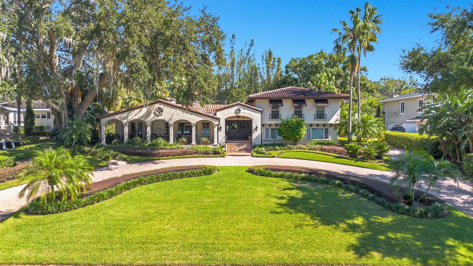 Discover this exquisite lakefront property located in the heart of Winter Park! Nestled on over an acre with more than 125 feet of water frontage, this home offers breathtaking views and absolutely stunning sunsets. As you step through the front door, you’re greeted by captivating lake views that flow from front to back. The spacious foyer leads to a charming living room, complete with a brick wood-burning fireplace. This area seamlessly transitions into the Florida room, an entertainer’s paradise featuring a wet bar, seating area and pool table, with easy access to a full bathroom that is equipped with a steamer shower. Open the French doors to reveal a tranquil outdoor oasis, where mature landscaping ensures privacy for the heated spa, creating a resort-like atmosphere in your own backyard. The heart of the home is a state-of-the-art chef's kitchen, boasting a large island, oversized GE refrigerator, Thermador dual ovens, elegant custom cabinetry, granite countertops, and a cozy breakfast nook. The spacious formal dining and living rooms offer beautiful lake views and lead out to a tranquil front terrace. For those who work from home, a private office on the main floor with a lake view provides an ideal and serene workspace. The large family room is perfect for everyday gatherings and is conveniently located next to a half bath. Upstairs, the primary suite overlooks the lake and features a walk-in closet and ensuite bathroom with a standalone Jacuzzi tub and separate shower. Two additional bedrooms share a full bath, while a generous fourth bedroom serves as a secondary primary suite with its own ensuite and walk-in closet. The property includes a paver circular driveway leading to a side-entry two-car garage.  Cross the brick paved road to a sprawling lakefront lawn, leading to a private boat dock with a lift, perfect for enjoying all the water activities. Located on Lake Sue, a private ski lake, this home is just minutes from Park Avenue's shopping and dining, Downtown Orlando, Baldwin Park, playgrounds, parks and excellent public schools. Don’t miss the opportunity to make this stunning lakefront home your own!