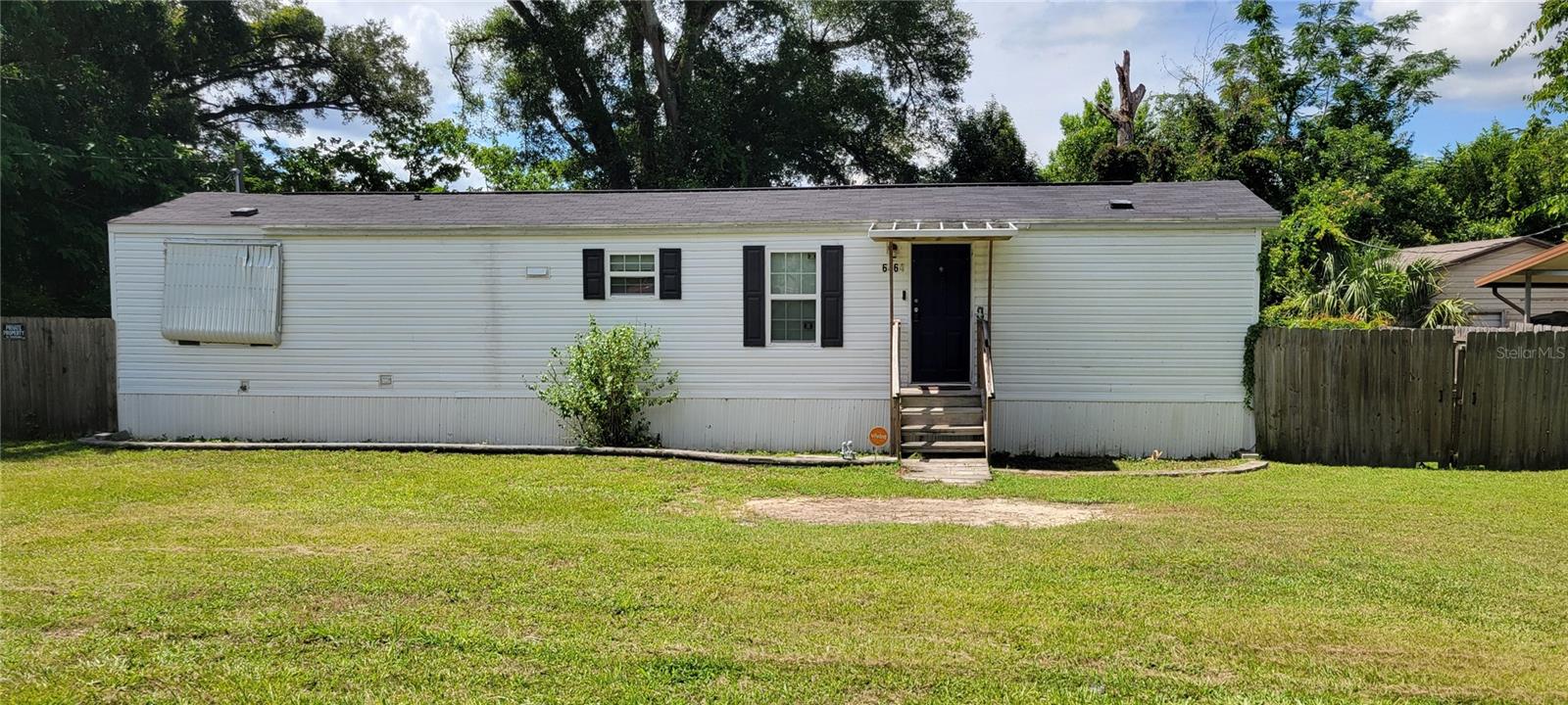 Very charming, 2 bedroom, 2 bath, single wide home on 1/4 acre lot....with NO REAR NEIGHBORS!  The back yard is completely fenced with two gates leading to the front.  There is a nice size storage building/garage, and a work shop (you may even find a spot for a man cave!).  There is plenty of room to park a motorhome and/or extra vehicles behind the fence.  An extra bonus room (15x9) and a screened-in lanai (24x9) have been added to the rear of the home, adding extra value to this cozy home.  The  home has a newer roof (5/2022) new water heater (7/2019) and a new A/C!  The home has some newer updates, including the en-suite bathroom with a newer vanity, commode and tub/shower combo.  This is a perfect starter home for a young family or a great landing spot for a retiree!  Home is equipped with a security system with multiple cameras and door bell camera ($30 monthly monitoring fee)  This home is just minutes away from the VA hospital, medical offices, restaurants, shopping, and entertainment!  Call today for your private showing!