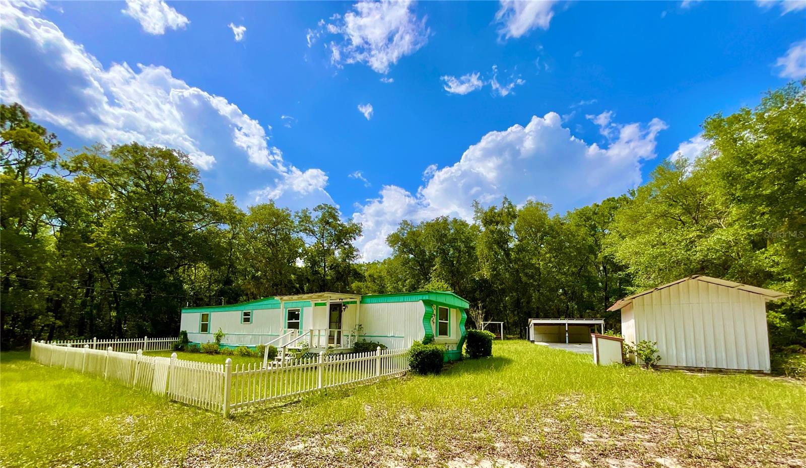 Just minutes from Historic Melrose Florida is this move in ready 2 bed 2 bath manufactured home on Lake Swan Road. The Large 2.7 acre partially wooded property is just beautiful and has paved road frontage. The split floor plan home has over 900 Sq ft. It has a large handi-capped accessed covered deck with a large open area for family gatherings. Other property features included are: an unfinished cottage, 2 car carport, large storage building, paved driveway, RV site with hookups and large deck. What a great place to enjoy some rural living again, yet being close to major towns like Gainesville, Palatka, Ocala and Starke Florida. But you'll find most all your conveniences just down the road in Historic Melrose and Keystone Heights: Restaurants, drug stores, Doctors, food stores, entertainment, cultural activities and for your recreational water enjoyment like: wake surfing, kayaking. fishing, skiing, swimming, there's 6000 acre Santa Fe Lake. See why so many are leaving the Big Cities and getting back to more of the country way of life and with this much property you'll have all types of opportunities. Raise some chickens, start a Victory garden and so much more. Showings are easy, give us a call and take a look.