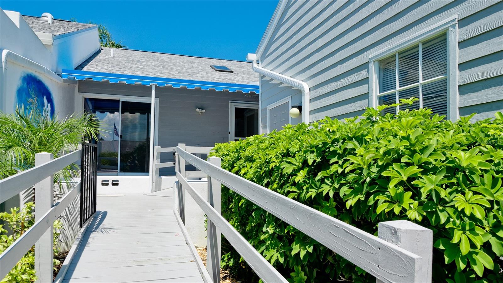 PERFECT VACATION VILLA WITH RAMP ENTRANCE TEN MINUTES FROM ANNA MARIA ISLAND BEACH IN GATED PERICO BAY CLUB.  This sunny, lakefront, high ceilings home with approximately 1600 sf has been completely updated in the last three years.  Two bedrooms, two en suite bathrooms, open concept living/dining area, glassed in lanai leads to the 8'x 22' large deck with electric awning overlooking the water lily filled lake. Not a condo, no one above or below you, like your own home. You can dine or grill on your west facing deck or
 in  your charming private entry courtyard. Roomy one car garage (14' x 19) has a side door entrance to your covered front door entry.  Wait till you see the lovely mural painting in your courtyard.
Improvements are numerous: attractive LVP flooring throughout, hurricane proof sliding glass doors to the deck & a brand new roof & skylight installed in 2025.
This new & improved one story coastal home has a handsome new kitchen with custom white cabinetry, white, Quartz counters, sparkling blue/green backsplash & shiny stainless Frigidaire Gallery appliances.  The Primary bedroom's beautiful bathroom has been updated with a gleaming walk-in shower, Quartz top vanity & new toilet.  Perico Bay Club has a fabulous location: 10 minutes west to Anna Maria Island & 10 minutes east to the mainland plus nearby Robinson, Perico & Neal Preserves. Amenities within Perico include smaller pools & spas in each of the 10 neighborhoods plus the larger Junior Olympic size lap pool next to the Clubhouse with Fitness Room, Library, meeting rooms & full kitchen. Tennis & pickleball courts, kayak storage & launch into Palma Sola Bay. Perico's 300 acres include 13 lakes are home to a variety of birds & marine life: white pelicans, roseate spoonbills, herons, egrets, turtles, hawks & eagles. 
This villa is located in the Home Owner's Association called Spoonbill Courtyard Homes. There are 42 villas in this HOA which has its own heated in the winter & chilled in the summer pool & spa. This HOA neighborhood is the newest Neal Homes built in 1992 & includes villas on both streets, Sanderling Circle & Woodstork Circle.