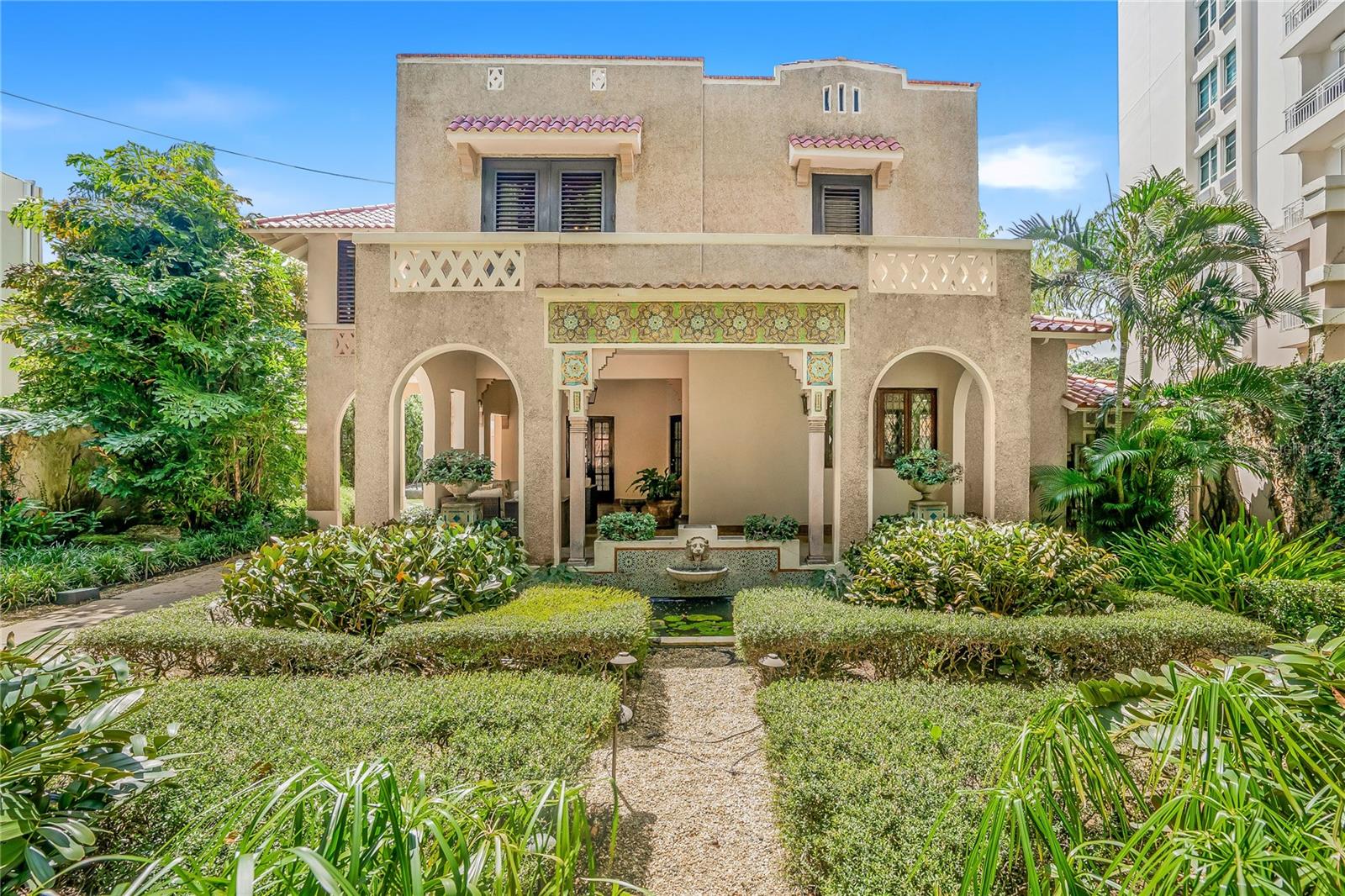 A piece of art in the iconic Spanish Revival style, this villa was meticulously crafted in the 1930’s by esteemed architect Pedro Adolfo de Castro. The historic gem spans 4,006 square feet of living space, featuring 5 beds/3.5 baths over two buildings. Located just one block from the widest expanse of beach on the most desirable residential block between Ocean Park and Condado, the property sits on a massive 1099 square meter lot. The land benefits from RT3 zoning, presenting a unique development opportunity. Whether inhabiting this cultural marvel or developing a larger structure, it must be seen and experienced. A vast Moroccan garden with water feature and lush landscaping greets visitors with dramatic flourish. As you approach the main entrance - look closely - tiny shells have been incorporated into the entire facade offering a glimpse of the intricacy that awaits. Open the front door and witness the sophistication of the interiors, featuring 12-foot ceilings, grand Spanish-style arches, original Terrazzo flooring with ornate bronze seams, custom mahogany woodwork, and Spanish wrought iron. The formal entry and living room are surrounded by windows, continuing the harmonious flow of the tropical gardens outside. Behind this grand reception room, a powder room with beautiful stained-glass windows, is conveniently located for visitors. Walk down the hallway, ornamented with immense arches for an aura of grandeur, to the formal library. Adjacent you’ll find a tremendous walk-in climate-controlled wine cave. The kitchen is conveniently located nearby and harkens to colorful, classic Puerto Rican cuisine, while equipped with stainless steel and all modern appliances. Connected to the kitchen is the informal dining area and wet bar. Float to the elegant formal dining room where a massive floor to ceiling window bathes the space in light. This accent window offers a new vantage point to witness the breath-taking sculpture garden and mosaic fountains outside, making for the most exquisite dining conversation. A grand bronze staircase ascends to the second level where you will discover the home’s 3 beds/2 baths, home office, and truly unique Moroccan sitting room. The expansive primary suite is a private sanctum of elegance and sophistication. Throw open the French doors to a romantic Juliette balcony overlooking the front garden below. Soak in the jacuzzi tub, an entire spa room apart from the ensuite bathroom for the ultimate in relaxation. A distinct walking bridge from the second floor leads to an additional recently remodeled living quarter, which includes 1 bed/1 bath, an office space, and a large area currently serving as an art gallery. From this level, ascend the grand outdoor spiral staircase, itself an architectural masterpiece, to view sunsets from the roof, or descend a second spiral staircase to the grounds below. The black bottomed pool, surrounded by mature tropical landscaping, is designed as both a beautiful focal point and for use and enjoyment. This entire residence is completely gated for the utmost security, while the driveway leads to an enclosed, private three-car garage. The property is equipped with an automatic Generac-Diesel 30 KLV generator and a 600-gallon water cistern, ensuring uninterrupted convenience. This home seamlessly blends contemporary amenities with preserved original elements, situated on one of the largest and most rare lots in Condado. Contact me today.