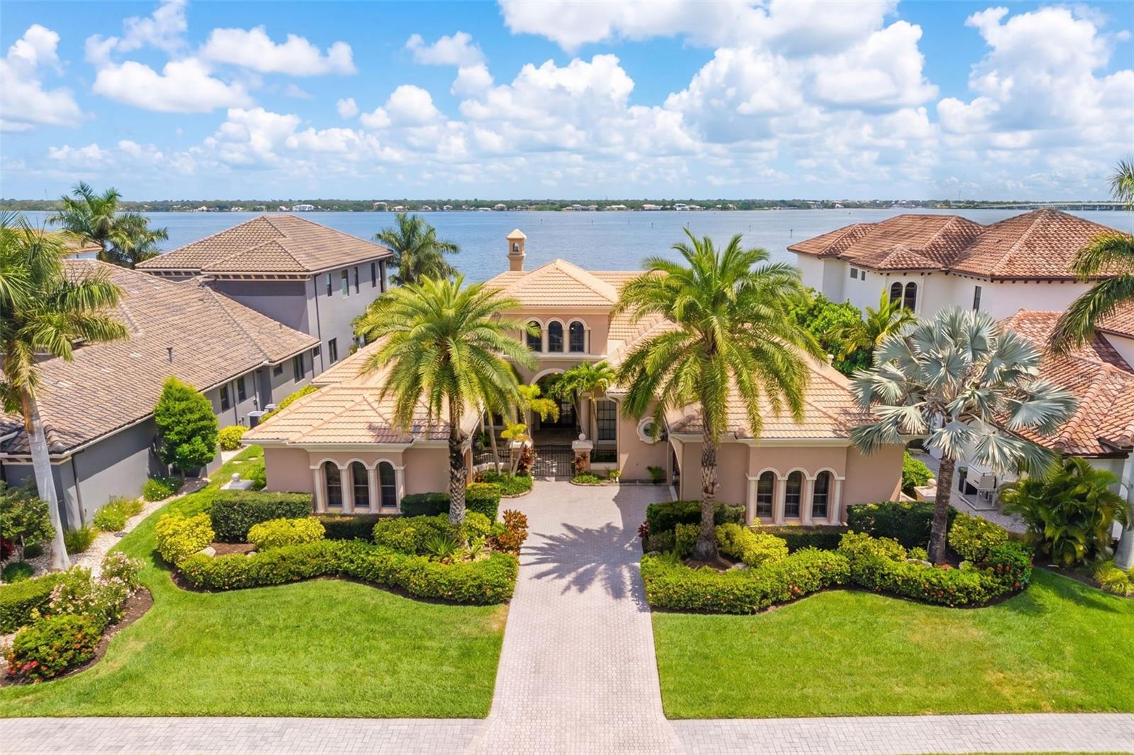 One or more photo(s) has been virtually staged. Within the exclusive gated waterfront community of Hawk Island, 4015 Hawk Island Drive offers a private estate experience with water on both sides, direct boating access, and a setting that stands apart in the Bradenton luxury market. The property features a front deep-water dock and a rear observation and fishing pier, creating two distinct waterfront experiences from one residence. Set along Hawk Island’s private peninsula roadway, the home offers privacy, scale, and protected boating access while remaining close to Anna Maria Island, downtown Sarasota, Lakewood Ranch, private clubs, waterfront dining, and Gulf beaches.
Designed to take full advantage of its surroundings, the residence features expansive living spaces, high ceilings, and walls of glass that make the water views part of everyday living. The floor plan works well for both entertaining and daily life, with an easy flow between the kitchen, gathering spaces, formal living areas, and outdoor terraces. The layout feels open while still offering separation, privacy, and flexibility throughout the home.
Outdoor living is one of the defining features of this property. Multiple covered lanais, elevated terraces, waterfront seating areas, and a pool and spa overlooking the water create a resort-style setting for year-round Florida living. The private dock provides direct access to the Manatee River, Tampa Bay, and the Gulf of Mexico with no fixed bridges, offering true deep-water boating convenience in a protected waterfront location.
The primary suite is designed to capture water views and privacy, while additional bedrooms, guest accommodations, and flexible living areas support multigenerational living, extended visitors, or changing lifestyle needs. Dedicated office and flex spaces add meaningful versatility for an executive workspace, fitness room, media space, or other personalized uses.
Mature tropical landscaping, generous garage capacity, and an expansive driveway approach strengthen the property’s sense of privacy and arrival. The home was designed to complement its coastal setting while offering the security and exclusivity associated with Hawk Island living.
Located near Sarasota, Lakewood Ranch, private aviation access, championship golf, waterfront restaurants, Anna Maria Island, and some of Florida’s most desirable Gulf Coast destinations, 4015 Hawk Island Drive stands apart in the Bradenton luxury waterfront market for its rare dual-waterfront setting, deep-water boating access, architectural scale, privacy, and elevated coastal lifestyle inside one of the area’s most distinctive gated communities.