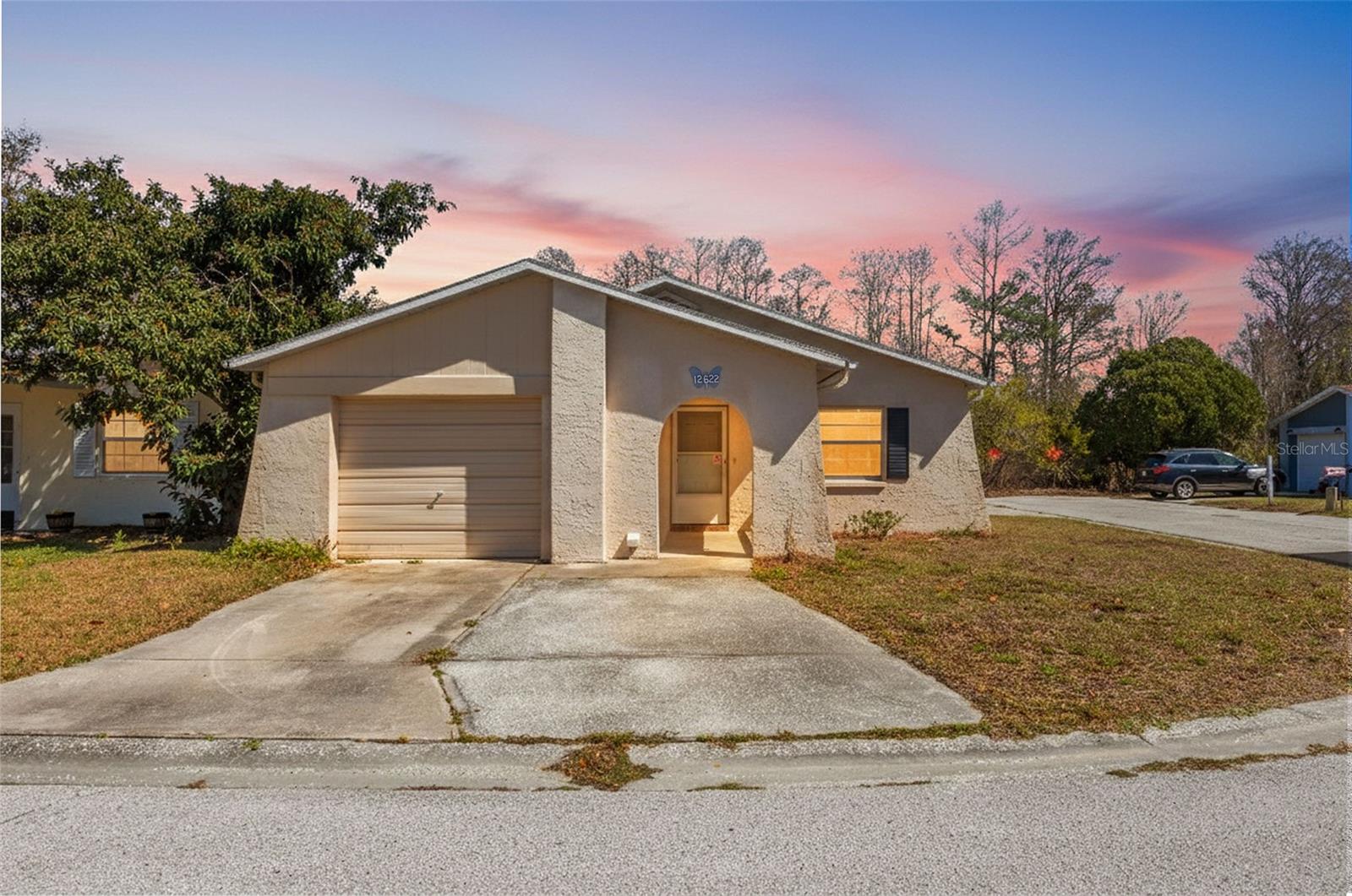 Welcome to this charming 2-bedroom, 2-bathroom home in Hudson featuring a unique and versatile floor plan designed for comfortable Florida living! This charming property offers fresh interior paint, brand-new carpet, and a newer AC system installed in 2023, providing peace of mind and move-in-ready convenience. Enjoy additional living and entertaining space with the enclosed sunroom, perfect for relaxing year-round, plus a screened lanai ideal for enjoying Florida’s beautiful weather while overlooking the backyard. One of the standout features is the full bathroom located in the garage — perfect for guests, hobbies, workshop space, or added flexibility. The thoughtfully designed layout offers spacious living areas and endless potential to make it your own. Ideally located near grocery stores, shopping, restaurants, and major thoroughfares, this home combines comfort, convenience, and value in one exceptional package. Whether you're looking for a primary residence, seasonal retreat, or investment opportunity, this Hudson gem is a must-see!