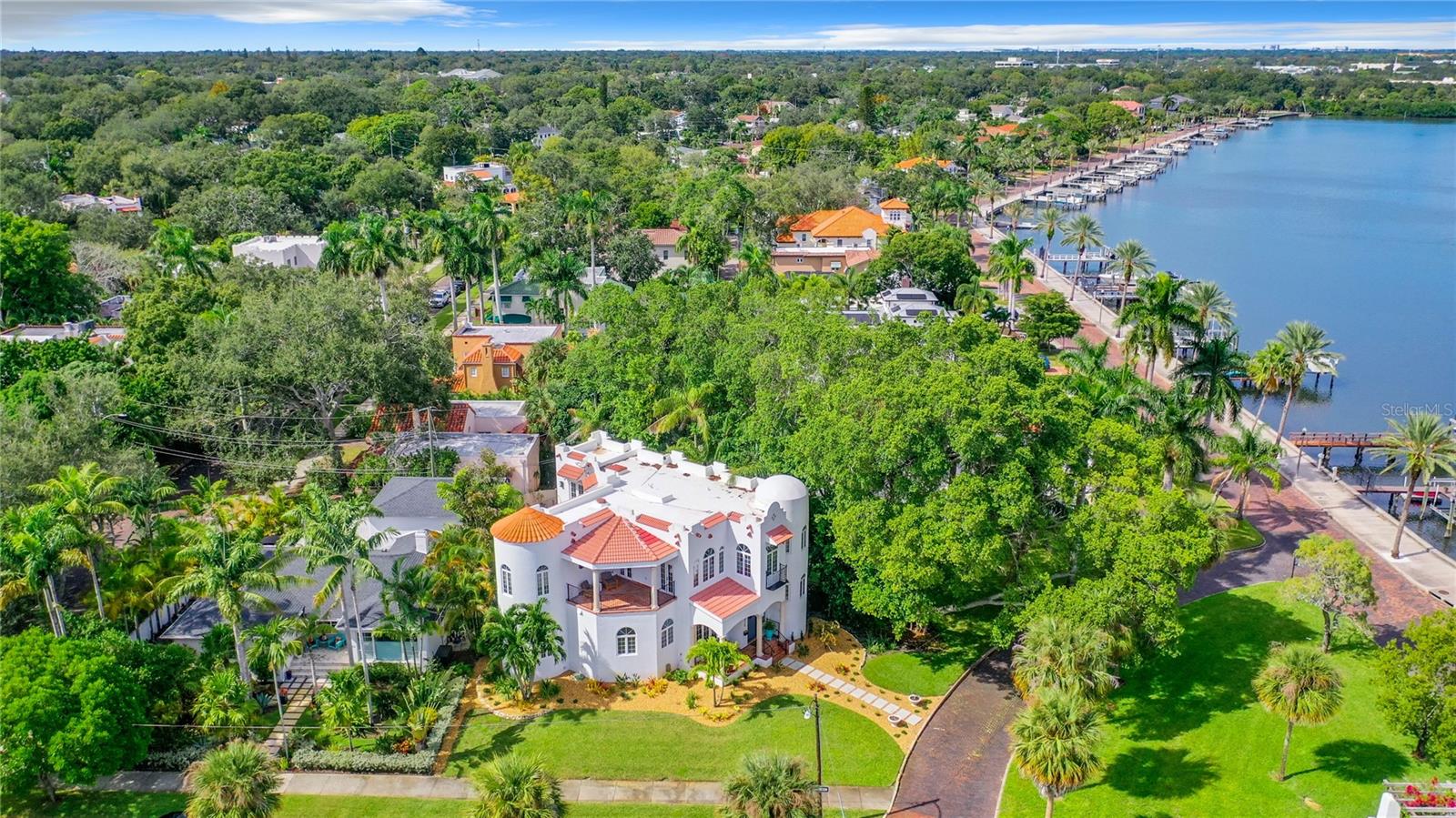 In 1924, C. Perry Snell platted the neighborhood known as Granada Terrace, with circular
plazas and curved brick streets. Today, Granada Terrace, with its concrete monuments and
verdant arbors is one of the most sought after neighborhoods in Historic Old Northeast Saint
Petersburg. A small enclave with a mix of Spanish and Mediterranean Revival homes and
traditional architecture is tucked along the shores of the Coffee Pot Bayou and trail. Steps
away, manatees gather daily in front of Granada Terrace Park and the famously photographed
pink Tabebuia which delights each year with its magical splendor, also resides here. In 2005,
this Mediterranean Revival home was built on a lot with exacting detail to encompass all of the
majestic sights of the area. In 2023, a designers eye updated this beautiful home and brought it
into a modern aesthetic while still keeping the Moorish and Spanish details that give this home
its wonderful character. Every space leads to sweeping views across the park and onto Coffee
Pot Bayou. Entering the home you will notice the polished concrete floors in juxtaposition to
the iron work and arches. The newly designed open concept floor plan highlights the modern,
glossy white kitchen and marble countertops. Repeating arches guide you into the living area
with a gorgeous fireplace and some privacy while still being adjacent to the activities and
provides a guest half bath. The dining area and eat in banquette embrace the panoramic views
overlooking the park and bayou. This fabulous entertaining space opens onto the private
courtyard with a cocktail pool, built in barbecue, another half bath and iron gates that lead to
the much desired two car garage with alley access. Wander up the light filled, winding
staircase to the landing which could be used as an office, play room, or quiet retreat. The
meticulously refinished wood flooring throughout adds a fresh glow to the upstairs. The primary
bedroom has been reconfigured to modern glory. A large terrace with Saltillo tile and Pecky
Cyprus ceiling overlooks the bay. The double vanities and black marble tile give nods to
modern and art deco periods. A soaking tub and stunning walk in shower combine the old and
new aesthetic. A custom walk in closet has been created providing the much needed storage
that is typically missing in older homes. Nicely situated away, but still down the hall are two
more bedrooms with ensuite baths. The laundry is conveniently located on this floor as well.
The newer construction of this home affords higher elevation and the modern desirable
amenities. Some of the many updates in 2023 are a new roof, all pool equipment and pool
remodel, A/C, gas tankless water heater, flooring and much more. Walk or bike ride or kayak
along waterfront trail which winds into downtown St. Pete where dining, sports, markets,
concerts and theatre abound. Truly the best best of both worlds in historic Granada Terrace
and vibrant downtown Saint Petersburg.