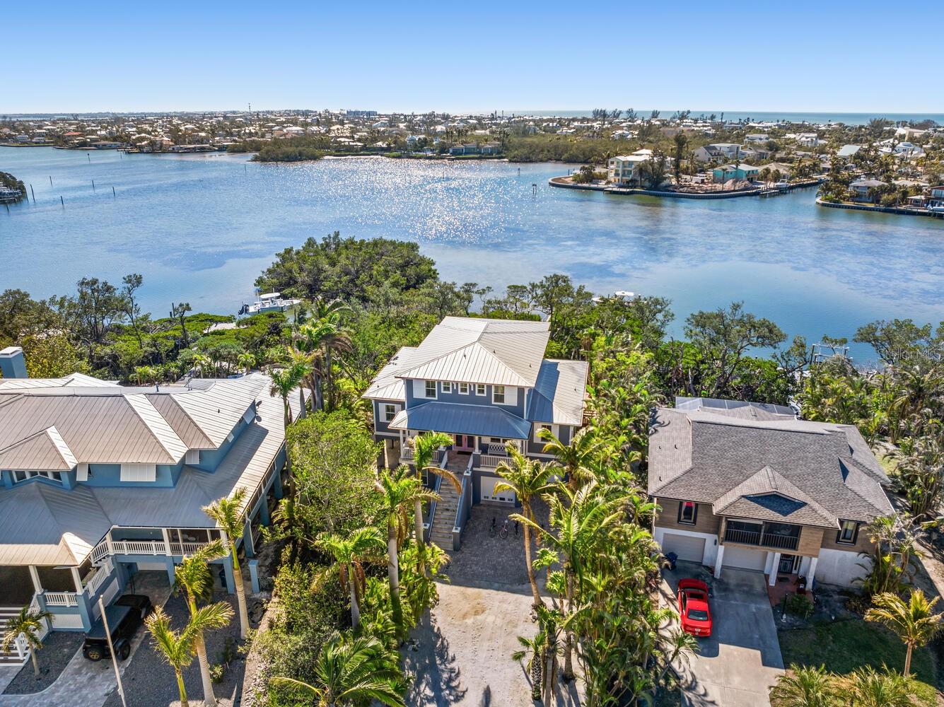 Quick question before you read on…. Are you here for business, pleasure or a little of both?  We ask because 517 Blue Heron is built and ready for all of the above! We challenge you to find a better performing asset on the island which can provide you actual rental history and income and NOT a management company’s sales pitch of pro-forma capability. Welcome to a truly rare waterfront gem on Anna Maria Island. This high-performing short-term rental generates nearly $200K annually while doubling as the perfect vacation retreat for you personally. Located on spacious open water—far superior to a canal—this 4-bed, 4-bath, 3,000+ sq. ft. home offers unparalleled water views and a 12,000 lb boat lift with dock (currently holding a 27’ center console) with no bridges between you and open water. Can you picture starting your morning off with a sunrise paddle board session? The resort-style outdoor spaces feature a heated pool, hot tub, grill, and covered dining area, all tucked away on a quiet cul-de-sac with no road noise. Enjoy the charm of Old Florida with modern luxury and the best of both investment and lifestyle in this island paradise!