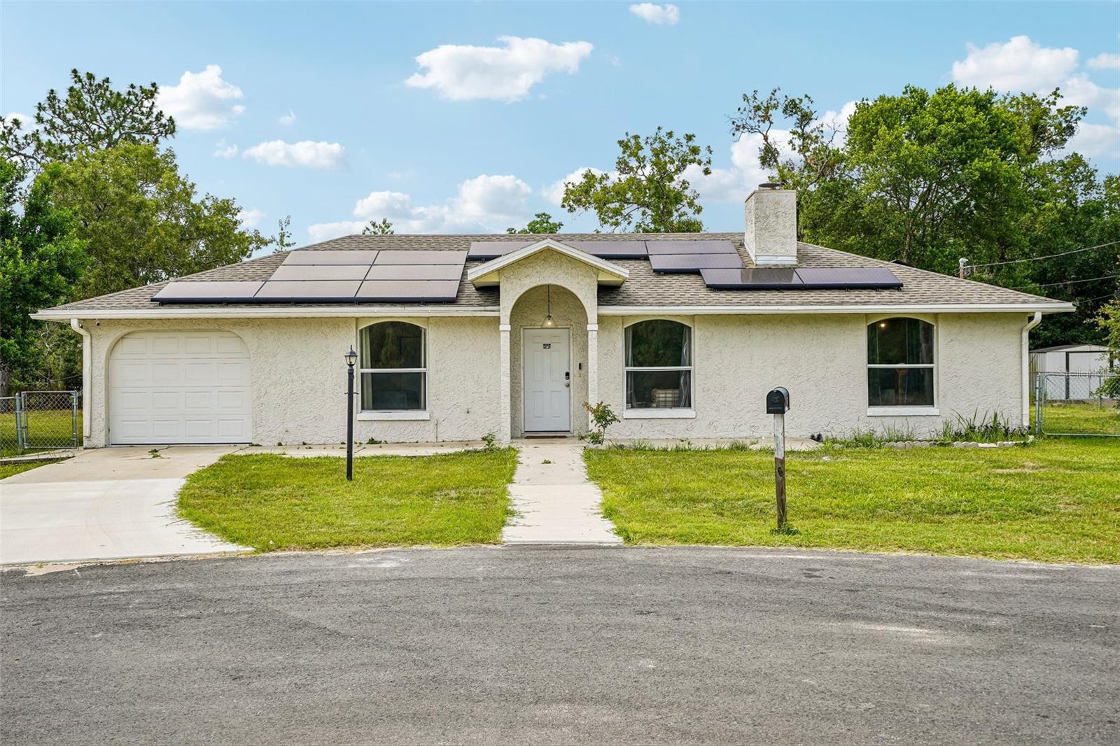 Welcome to this inviting 3-bedroom, 2-bathroom single-family home offering 1,434 square feet of comfortable living in Ocala, FL, ideally positioned on a quiet cul-de-sac. Recent upgrades bring added value and peace of mind, including solar panels installed in 2023, a solar water heater (2023), a new HVAC system (2024), and a new well tank (2026). Inside, the living room features laminate flooring, high vaulted ceilings, and a cozy fireplace that creates a warm focal point for the home. The kitchen is designed for both function and flow with tile flooring, stainless steel appliances, ample cabinet and counter space, and a dining area just off the kitchen, perfect for everyday meals or entertaining. The primary bedroom includes a private en-suite bathroom with a walk-in shower. Additional bedrooms are generously sized, offering flexible space for a variety of needs. Out back, enjoy a spacious yard complete with an above-ground pool installed in 2025, providing a great setting for outdoor relaxation and gatherings. Conveniently located near grocery stores, dining options, and major highways, this home offers easy access to everyday essentials and commuting routes while still maintaining a tucked-away neighborhood feel. Mortgage savings may be available for buyers of this listing.