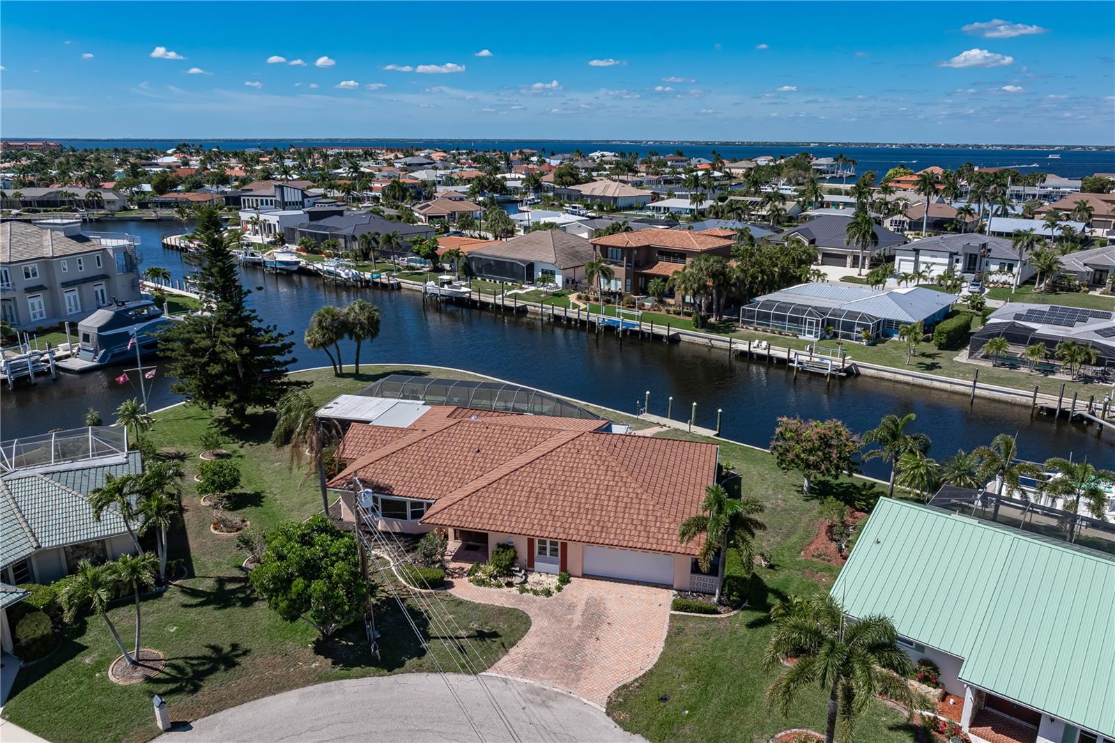 WATERFRONT HOME W/NEW ROOF ON OVERSIZED TIP LOT & EXTREMELY QUICK SAILBOAT ACCESS!!! Opportunities like this don’t come up often: a rare, oversized tip lot located in the original sailboat section of Punta Gorda Isles with 183 feet of seawall, intersecting canal views, and quick, deep water sailboat access to open water. SO MUCH POTENTIAL HERE!! Spanning nearly 3,000 sq ft, the 3 bed/2.5 bath + den home was designed with the canal view in mind. A wall of sliding glass doors lines the rear, bringing in natural light and creating a seamless connection to the lanai and pool. The layout is spacious and functional, with multiple living areas and a natural flow that already lends itself to modern living. Home is ready for renovation w/NEW STONE COATED METAL TILE ROOF and great bones already in place. There are terrazzo floors peeking through in several rooms just waiting to be restored - a detail that speaks to the home’s timeless character. The footprint is there, the space is there, and the split bedroom layout makes sense - it just needs the right vision to bring it back to life. The screened lanai and pool overlook the wraparound view of intersecting canals. Dock is positioned off to the side so it doesn't interfere with the view. Bring your imagination and restore this amazing home. OR consider building your own, custom masterpiece here. Buy for the amazing lot and imagine what is possible - a home that is truly one-of-a-kind. The size and the shape of the lot allow you to create something truly exceptional, something that can't be replicated. Enjoy some of the best fishing and boating from your backyard with an existing 25ft concrete dock. This FANTASTIC LOCATION means this home is just moments from the Isles Yacht Club, historic downtown Punta Gorda, and numerous local parks. Whether walking, biking, boating or driving, you’ll find yourself close to shopping, dining, and entertainment. Discover for yourself why Punta Gorda is often considered among the best places to live, work, and retire in SW Florida.