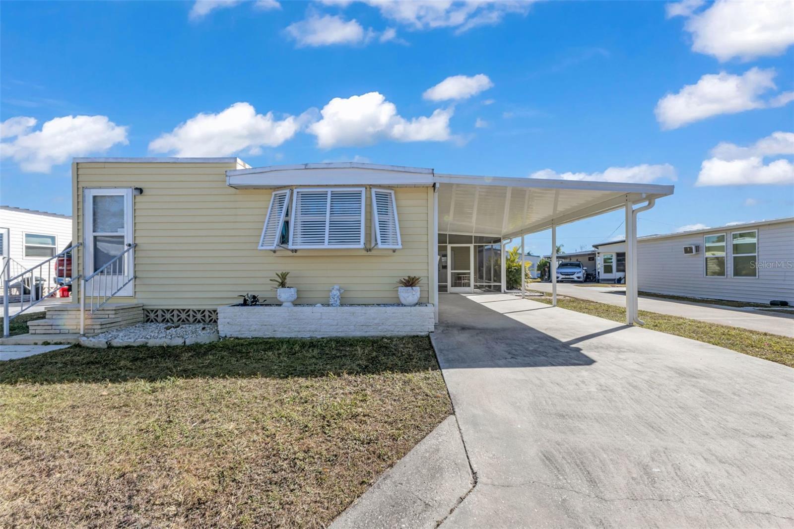 Welcome to 1891 Englewood Rd in the desirable Brook to Bay community! This charming 2-bedroom, 1.5-bath residence features a fresh, inviting interior with all-new laminate flooring throughout, an updated kitchen, and stylish shiplap accent walls that add a coastal flair. Just off the entry is a foyer that would make an excellent flex space for visiting guests, home office, or reading nook. Enjoy Florida living year-round in the screened lanai, perfect for relaxing or entertaining, plus additional storage space located at the rear of the lanai. Additional features include Bahama shutters and convenient carport parking. Discover the vibrant Brook to Bay 55+ co-op community, offering an active lifestyle and wonderful amenities, including a heated community pool, bocce ball, shuffleboard, clubhouse, picnic area, boat ramp, and boat slips available on a first-come basis. Ideally located near beautiful Gulf beaches, shopping, restaurants, and golf courses, this home is a fantastic opportunity to enjoy coastal Florida living!