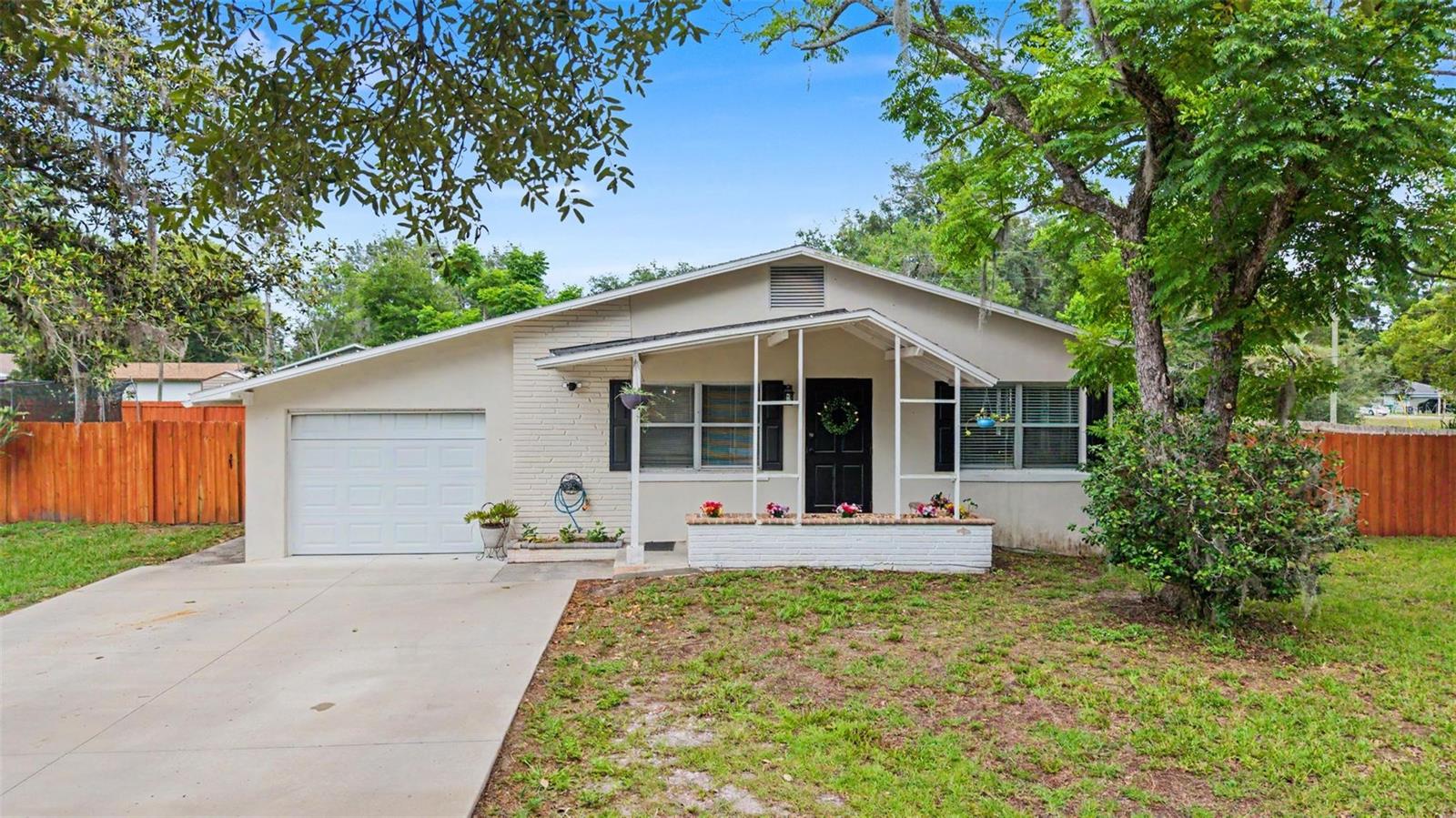Welcome to this charming and versatile 3-bedroom, 2-bath home situated on an expansive 0.42-acre corner lot in the heart of Zephyrhills. With approximately 1,288 square feet of heated living space plus a 156-square-foot bonus room with its own wall A/C unit, this property offers flexible living options for today's lifestyle.  The kitchen features attractive stone countertops and a designated dining area, creating a functional and inviting space for everyday living. A unique bonus room connected to the primary bedroom through French doors also offers its own separate exterior entrance, making it ideal for a home office, nursery, guest room, hobby space, or potential fourth bedroom.  Significant improvements include a new roof (2020), a newly added driveway, and a 6-foot wooden privacy fence enclosing the perimeter of the property. Fresh interior and exterior updates enhance the home's appeal, while the spacious backyard provides endless opportunities for entertaining, gardening, or simply enjoying the outdoors around the fire pit.  One of this property's standout features is that it encompasses three separate lots (Lots 10, 11, and 12) totaling approximately 0.42 acres. The oversized corner parcel offers exceptional outdoor space along with exciting future possibilities. Buyers interested in additional development or construction opportunities should verify zoning and permitting requirements with local authorities.  Whether you're looking for room to spread out, space to entertain, or future potential, this property offers a rare combination of flexibility, privacy, and value. Schedule your private showing today!