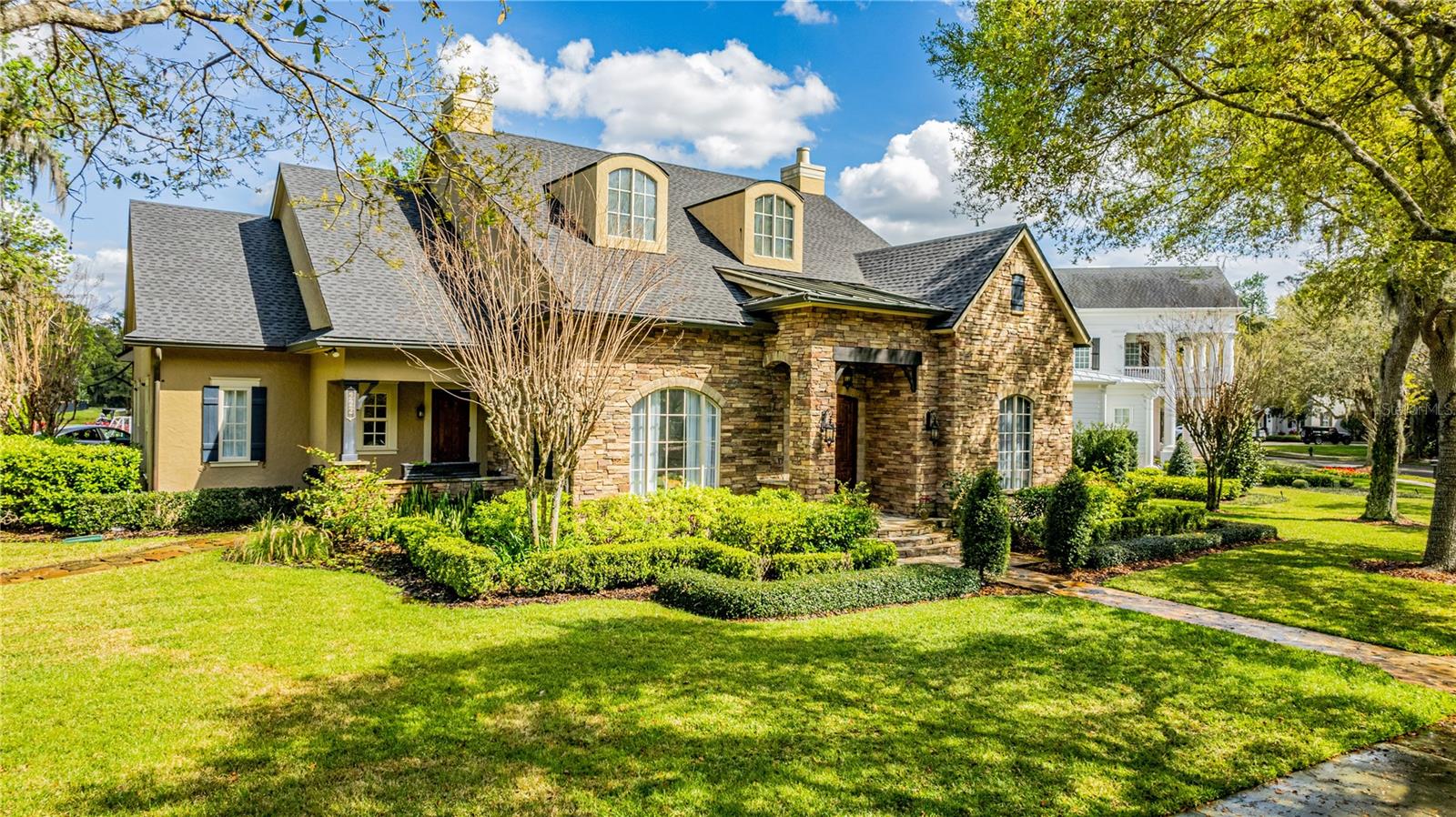 Welcome to this stunning custom residence by Derrek Builders, perfectly situated along the renowned Celebration Golf Course designed by Robert Trent Jones Sr. and Jr. With over 5,800 sq. ft. of thoughtfully designed living space, this home blends timeless architecture with modern luxury. From the moment you enter, the open layout captivates with its elegant details: a formal dining room with custom window treatments, a warm family room with a stone-accent wall and beam ceilings, a cozy gas fireplace, and a sophisticated office complete with custom-built wooden bookcases. Rich cherry hardwood flooring flows throughout, setting a refined tone. The gourmet kitchen is a chef’s delight, featuring quartz countertops, tile backsplash, premium cabinetry with custom lighting, a spacious center island, and high-end stainless-steel appliances. An inviting breakfast nook and upgraded lighting enhance the space. Additional conveniences on the main floor include a mudroom, walk-in pantry, laundry room with washer/dryer and double sink, plus a private gym overlooking the outdoor retreat.
The owner’s suite is a private haven, where large picture windows allow natural sunlight to stream in, adding brightness and elegance to the space. The luxurious master bathroom features dual vanities, a Jacuzzi tub, a grand walk-in shower, and his-and-hers custom closets with fine cabinetry, creating a true spa-inspired retreat. 
Upstairs, enjoy a private cinema room with full bath — perfect for movie nights — along with two generously sized bedrooms and another full bath.
Above the garage sits a complete one-bedroom apartment with its own entrance — ideal for guests or extended family. The apartment boasts a full kitchen with granite countertops, stainless steel appliances, a dining and living area, private laundry, a spacious bedroom, walk-in closet, and full bath.
Step outside to your personal oasis: a heated saltwater pool, expansive patio, and an entertainer’s dream outdoor kitchen with granite island, wine fridge, ice maker, dishwasher, gas stove, grill, pizza oven, built-in refrigerator, and a full bath. Enjoy sweeping views of the scenic par 3, hole #13 of Celebration Golf Club, along with serene conservation areas.
Recent updates include a new roof (2023), new HVAC for the main level and primary suite (2023), and updated upper floor/garage apartment HVAC (2021). Additional features include energy-efficient double-pane windows, crown molding, wainscoting, epoxy garage flooring, intercom system, and more.
This remarkable property offers a rare combination of luxury, functionality, and unmatched views. Don’t miss your chance to call it home — schedule your private tour today!
