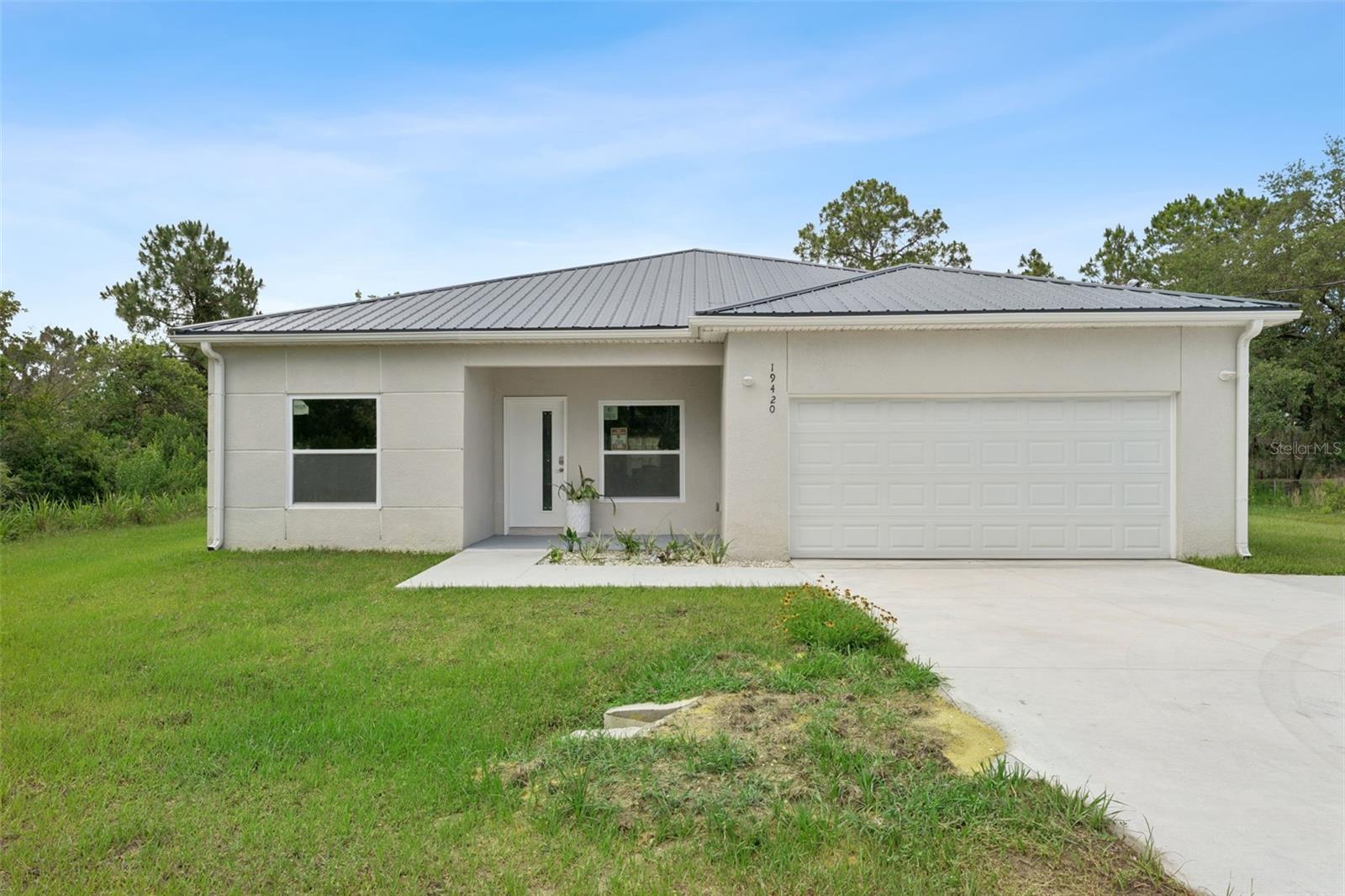 Welcome to this brand-new, never-lived-in custom-built steel-framed home, set on just over one acre in the highly desirable Wedgefield community.  This spacious 5-bedroom, 3-bathroom home features an open split floor plan with soaring 9-foot ceilings and durable vinyl flooring throughout. Designed with both style and functionality in mind, the kitchen serves as the heart of the home with custom European-style cabinetry, stainless steel appliances, quartz countertops, and a large waterfall-edge island with seating—perfect for entertaining, in the heart of the home and living spaces.
The luxurious primary suite offers dual walk-in closets and a spa-inspired bathroom featuring a freestanding soaking tub, separate shower, and dual vanities. And best of all? A private mini suite with its own entrance provides an ideal setup for guests, extended family, in-law accommodations, or young adults needing their own space but not yet ready to leave the nest. A great opportunity as well for multi-generational living or future rental potential.
Additional highlights include an energy-efficient zoned heat pump mini-split A/C system, offering environmentally friendly climate control, lower utility costs, and personalized comfort throughout the home, deep well with water treatment system, covered front entry, and a spacious 2-car garage. With plenty of room for animals, recreation, or simply enjoying the surrounding natural setting, this exceptional property offers the perfect combination of privacy, modern living, and adorability and convenience. 
Surrounded by mature trees and natural greenery, this private retreat offers peaceful living while remaining conveniently located just 25 minutes from downtown Orlando, 18 minutes from the airport, and only 35 minutes from the beaches. Don’t miss the opportunity to own this stunning new construction home—schedule your private showing today!