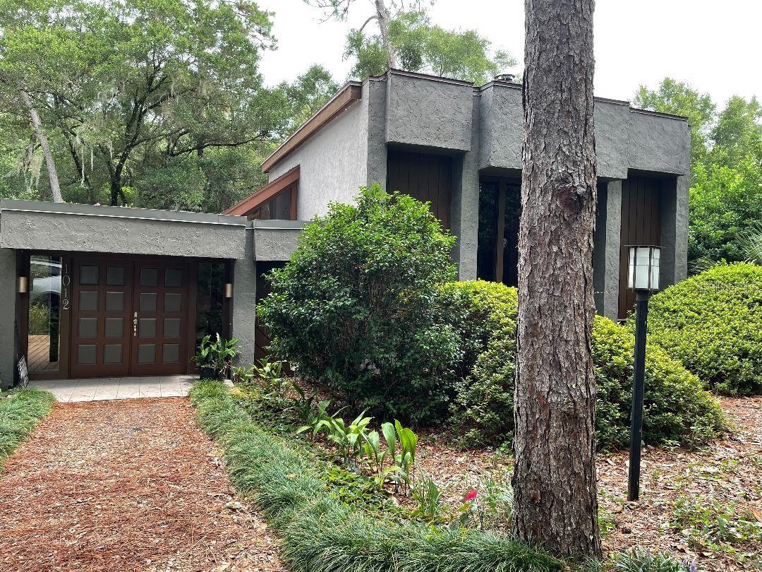 Came through Hurricane Ian with no problems! Move in Ready! Modern mid-twentieth century architectural style home designed by John DeLong and built by Delo Builders in 1977. This unique 3 story home is hidden from the street in a beautiful Florida hammock of Oaks and Pines. 3 bedrooms, 3 baths, double sided fireplace in living/family room, screened courtyard with Koi pond, separate bonus room with its own AC unit, wet bar,  and fireplace, lots of outside decking, attached 2 car garage/basement with lots of storage. Circular drive and extended driveway to garage located in the rear of the home.  All this on a half acre lot. Located on a cul d sac with walking and bicycle trails. ;Water: City