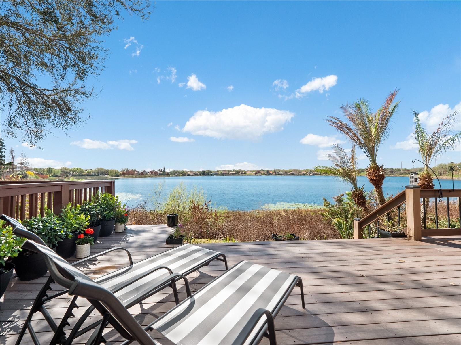 Absolutely stunning LAKEFRONT town home with breathtaking water views in the highly sought-after guard-gated community of Vizcaya, right in the heart of Dr. Phillips! Step through the impressive 8-foot entry door and immediately notice the fresh interior paint, elegant crown molding, and magnificent engineered hardwood flooring flowing throughout the main level. Natural light pours into the home, creating a warm and inviting space that truly feels special. The first floor offers two spacious living areas, both showcasing spectacular lake views, the perfect backdrop for relaxing evenings or entertaining friends and family. Step outside onto the expansive deck overlooking the water, an ideal place to gather with loved ones or unwind at the end of the day while enjoying the peaceful lakefront setting and the lifestyle this beautiful home offers. The chef-inspired kitchen is a true showpiece, featuring real wood cabinetry with upper and under-cabinet lighting, exotic granite countertops with a bullnose finish, stainless steel appliances, and a beautiful breakfast bar that flows seamlessly into the dining nook. Downstairs also offers a generous laundry room with sink and ample cabinet storage. TANKLESS WATER HEATER and NEW HVAC (2024) provide peace of mind and make this home truly move-in ready, just bring your bags! Upstairs, durable stain-resistant Berber carpet leads you to two expansive loft areas offering endless possibilities for a home office, media room, or additional living space. The primary suite is a true retreat featuring a beautiful bay window as well as a fabulous balcony where you can even catch fireworks in the distance, especially on holidays! Enjoy a spacious walk-in closet with custom organizer and a private balcony perfect for sipping your morning coffee while taking in peaceful lake views. The en-suite bath features a relaxing jacuzzi tub, walk-in shower, and dual vanities. Two additional guest bedrooms are generously sized with walk-in closets, newer ceiling fans with lights and share a convenient Jack-and-Jill bathroom. Vizcaya offers resort-style living with amenities including a community pool, fitness center, gated dog park, and picnic areas. Located walking distance to Restaurant Row and zoned for A-rated schools, with easy access to I-4, Orlando International Airport, and Central Florida’s world-class shopping, dining, and entertainment. Lakefront end-unit opportunities in Vizcaya are rare, schedule your private tour today and experience it for yourself!