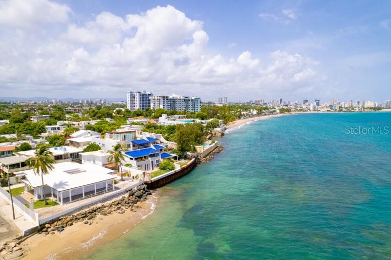 Villa Mare is a century-old dwelling that has steadfastly watched over this privileged oceanfront spot of 1,122 sq. mt. in Punta Las Marías, one of the most beloved seaside communities in town, featuring controlled access and nighttime security patrols. The property's most recent renovation, completed in 2020, stayed true to the original architectural style, evoking a nostalgic era of Caribbean elegance and carefree living in a classic bungalow setting.
The heart of the home is its central courtyard, whose gravitational pull draws people together as sunlight and moonlight filter through, enriching the indoor ambiance. Wraparound porches invite you to immerse yourself in the beauty of the sea and sky, while the gentle lullaby of the West Indies trade winds beckons you to a peaceful siesta.
For entertaining or relaxing, the outdoor bar and jacuzzi provide the perfect setting for gatherings with family and friends. Additionally, a two-bedroom, one-bath guest house offers comfortable accommodations for your visitors.