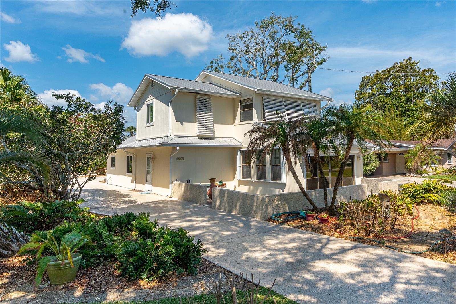 Welcome to this beautifully maintained Riverside Dr. 3-bedroom, 2-bath home situated on a desirable corner lot with easy, convenient access from a quiet side street. Perfectly positioned to enjoy peaceful water views, the property is nicely landscaped and offers a welcoming first impression with lush greenery and curb appeal. Step inside to find a thoughtfully designed layout that balances comfort and entertainment. The large kitchen flows seamlessly into the dining and living areas, creating an open and inviting space for everyday living. Adjacent is the spacious enclosed and air-conditioned lanai featuring a wet bar—ideal for gatherings, casual entertaining, or relaxing while taking in the water views. Upstairs, the oversized primary suite provides a private retreat with an enclosed porch with water view perfect for relaxation. It is also complete with a luxurious walk-in shower and step-in Jacuzzi tub. A chair lift also ensures easy access to the second story for added convenience. Two additional bedrooms and a full bath on the ground floor offer convenient living options or comfortable accommodations for stay-overs. This home boasts impressive upgrades for peace of mind and low maintenance, including a durable metal roof, new windows throughout, and hurricane shutters. Additional highlights include an oversized 2-car garage with extra parking space next to it for a boat or RV. The driveway and patio have been recently enhanced with attractive decorative epoxy coating for both style and durability. Irrigation well and system. Whether you're looking for a primary residence, a vacation home, or an investment property, 1818 S. Riverside Drive delivers comfort, functionality, and Florida water view living at its best. Information is assumed accurate but not guaranteed. Measurements are approximate. Buyers and their agents must verify all information that is important to them.