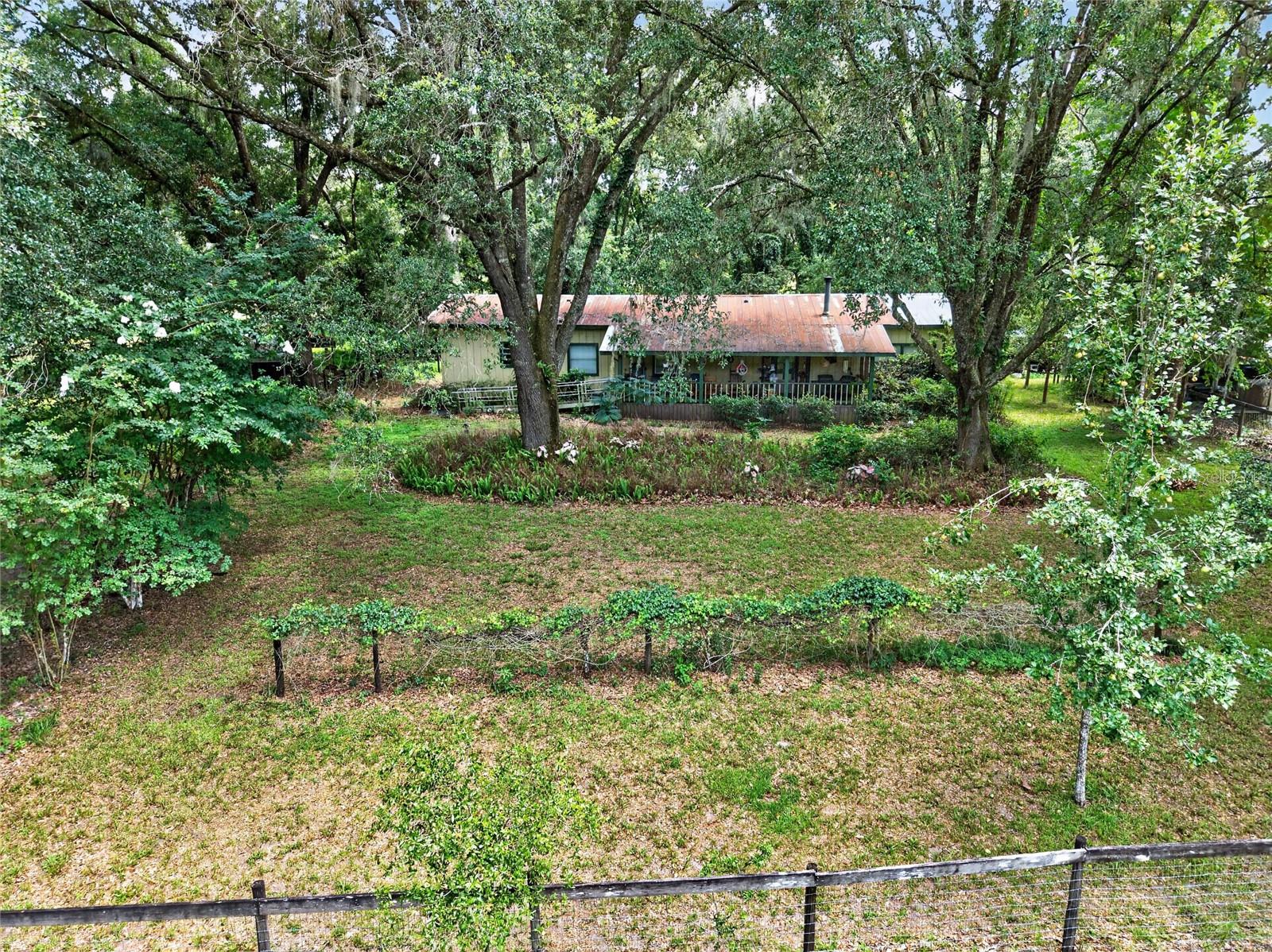 Welcome to 15 cleared acres that have been lovingly cared for by the same family for more than 50 years. This special property is ready for its next chapter, offering possibilities for those looking to create their dream homestead, equestrian property, or country retreat. As you enter the property enjoy the Grandaddy Oaks.  You'll find a 1,752-square-foot manufactured home, originally built in 1972, with a wood-framed exterior, metal roof and covered front porch. Inside, the home features a living room with a wood-burning stove,  dining area and a comfortable kitchen with an eat-in island. Down the hall are three bedrooms and two full bathrooms. At the rear of the home are two additional flexible-use rooms with exterior access. Large side storage areas provide storage space and house the washer, dryer with a dedicated water heater. The property is well-equipped with multiple outbuildings, including two carports, an RV/camper barn with two office or storage rooms, a separate storage shed, a four-stall stable and two fenced pastures. The home and outbuildings offer an opportunity for renovation and updating and repairs are needed. Whether you choose to restore and improve the existing structures, live in the home while building your custom residence or reimagine the property entirely, this is a rare chance to own 15 cleared acres with established infrastructure and room to bring your vision to life. The land has been cherished for decades and is ready for a new owner to write its next story.