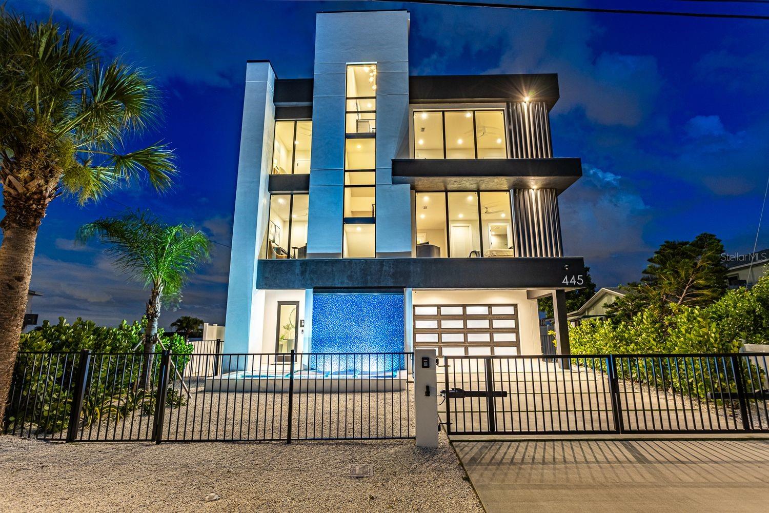 Auction Property. LUXURY PRIVATE AUCTION. This property is being offered via luxury private auction. Submit offers now through June 18th. Seller may accept or reject bids at any time. Visit Paramount Realty USA’s website for full terms and details.

This architectural marvel, designed and developed by Tulia Homes, is an artistically thoughtful residence that is the epitome of luxury waterfront Florida living. Location is everything with this home, which is nestled on a peninsula overlooking Boca Ciega Bay, with clear sightlines to Little Bird Key and Eleanor Island. You can enjoy ocean breezes with sunsets or sunrises, whether you experience them inside or out. Owning this home is more than owning a house — it's a lifestyle, and it does not disappoint. Your private dock allows convenience when you embark on boating excursions to the Gulf, with quick and easy access through John's Pass. This 5,785 sq. ft. residence boasts an open-floor living space for ultimate entertaining, five bedrooms, four en suites, one and a half guest baths, a gym/yoga meditation room, pool/spa, 360-degree view rooftop, and an eight-car parking garage. Enjoy picturesque views from every corner of this home. Floor-to-ceiling windows overlooking the ocean to the east allow for perfect sunrises as dolphins swim by while you sip your morning coffee from one of the expansive terraces or relax by the saltwater pool. High above sea level is the main living space, thoughtfully designed for coastal living and entertaining. A chef's kitchen, butler's pantry, two living areas, wet bar, temperature-controlled wine room, and a dining room all overlook the shimmering sea. All of this can be enjoyed with the entire wall of windows automatically opening to the fresh ocean breeze. This level also has two guest bedrooms (or office) with en suites, walk-in closets, and a powder room. On the second floor, you will find two guest bedrooms, two bathrooms, a fitness room, laundry area, an informal living room, and a spacious and serene primary suite with its exquisite spa-like bathroom equipped with a breakfast bar, double shower, soaking tub, and formal dressing room. Next, take the all-floor-access elevator up to the third floor and be greeted by a wet bar, which leads you to an incredible 360-degree view rooftop — perfect for spectacularly memorable sunsets or improving your putting skills, all while overlooking the ocean.
All of this is located just steps away from the John's Pass Boardwalk, John's Pass Park & Beach, and everything Gulf Boulevard has to offer. Tulia Homes doesn't just build homes — they build sanctuaries for joy, pride, and cherished memories with family and friends for generations to come!
Contact us today to schedule a private tour of this breathtaking and visually stunning property, sitting at the access point of the Gulf and the apex of Florida coastal living