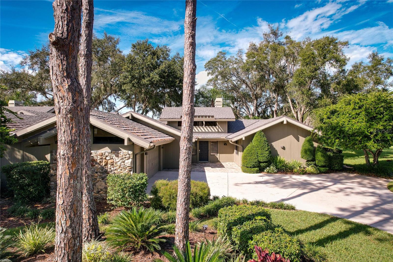 If you are looking for a home that is the perfect blend of luxury, functionality, and a breathtaking setting, that offers a lifestyle that caters to both relaxation and entertainment, THIS IS THE HOME FOR YOU! This 3 bedroom/ 3 bath, 2,483 sq ft maintenance-free home is COMPLETELY RENOVATED INSIDE  and not only overlooks a gorgeous pond but is also the 8th hole of the BEAUTIFUL Saddlebrook Golf Course! Enjoy the gorgeous sunsets and the water/golf course view from not just your patio but also your living room, family room, kitchen, master bedroom, and master bath! The abundance of natural light that flows through the large windows, sliding glass doors, and skylights creates a bright and airy atmosphere that showcases all the beauty of the backyard and golf course. This open-plan cluster home has all NEW Engineered hardwood throughout!  The kitchen truly is a chef's dream! The chef's dream kitchen is equipped with top-of-the-line amenities, new custom-designed cabinets, luxury high-end Quartz Countertops, a built-in microwave, stainless steel appliances, built-in double wall gourmet ovens, a range hood, an induction top cooktop, a pull-out pantry, and a wine cooler/beverage fridge, perfect for entertaining. The open layout and eating bar area make it perfect for both cooking and entertaining. The kitchen opens up to the formal dining room area overlooking those gorgeous views. Two of the three bedrooms have their own beautifully renovated private bathrooms, as well as walk-in closets with closet organizers/shelving. The master bath, with its double sink vanity and large garden tub, offers a relaxing retreat after a day of golf.  The oversized back porch with its new ceramic tile, drain system, and breathtaking views is perfect for entertaining or simply enjoying the panoramic surroundings. It truly is one of the best views in all of Saddlebrook! The family room, is complete with a wood-burning fireplace and hurricane-impact sliding glass doors, providing a cozy and inviting space for relaxation. The home's new hurricane/storm-rated sliding glass doors and plantation shutters/electric roll-up shades add privacy and a layer of safety and protection to the home. High ceilings and ample closet and cabinet space throughout the home offer practical storage. The spacious 2.5 oversized car garage has plenty of room to park your cars as well as a separate space for your golf cart. The HOA fee covers the roof, grounds, landscape maintenance, pest control of the exterior, building maintenance and exterior insurance,  pool maintenance and 24-hour guarded gates. Saddlebrook offers two of Florida's most beautiful pristine golf courses and has 45 tennis courts where many professional tennis players have played! The home is close to Wire Grass, the Outlet Mall, I-75, Hospitals, Shopping, and Restaurants. Make your appointment to see this beauty today!